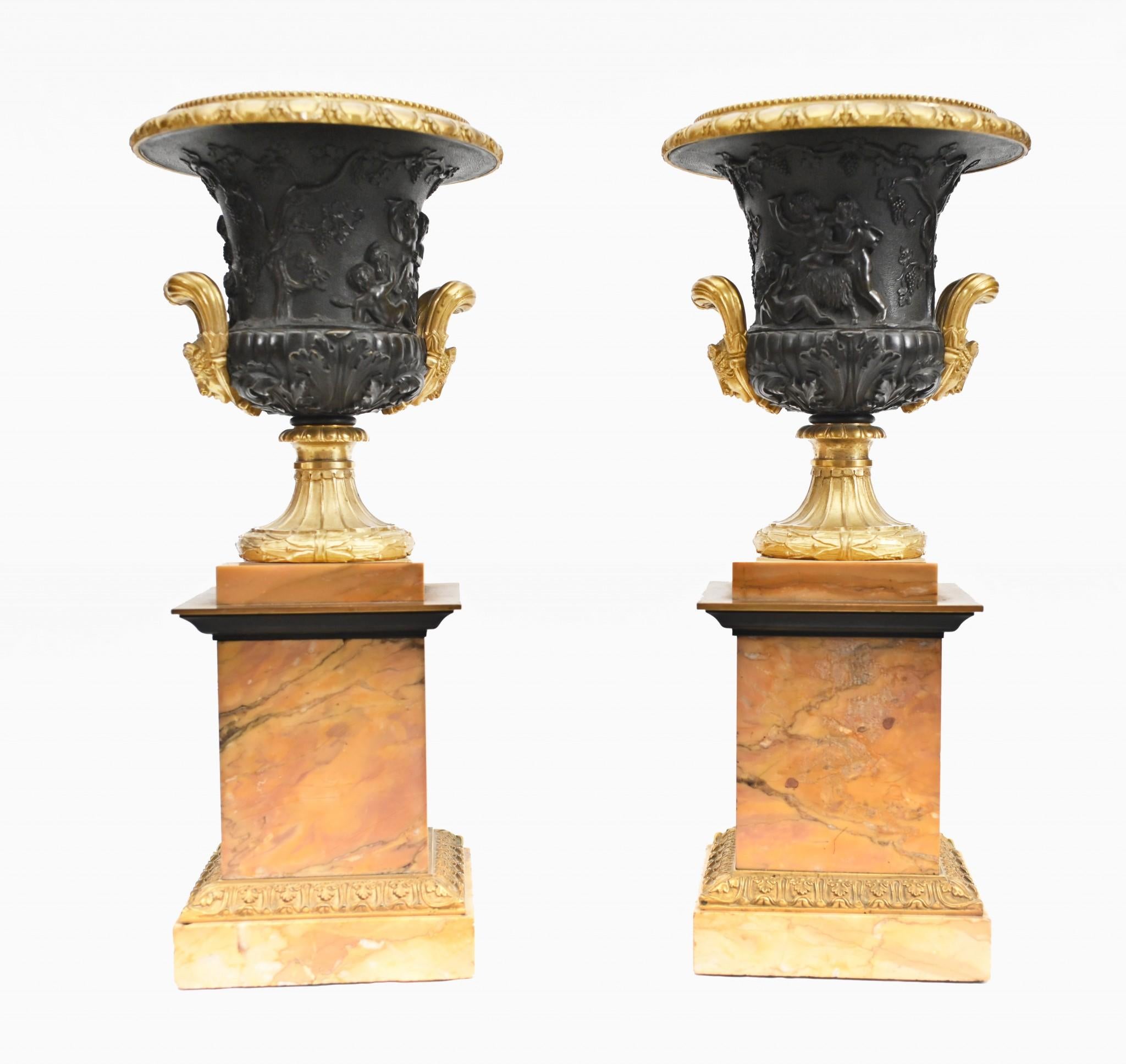 Absolutely stunning pair of bronze urns mounted on salmon pink marble pedestals
The urns feature cherub scenes in relief around the urns as the partake in a Bacchanalian revelery whilst imbibing the grape
These are a fabulous, high collectable pair