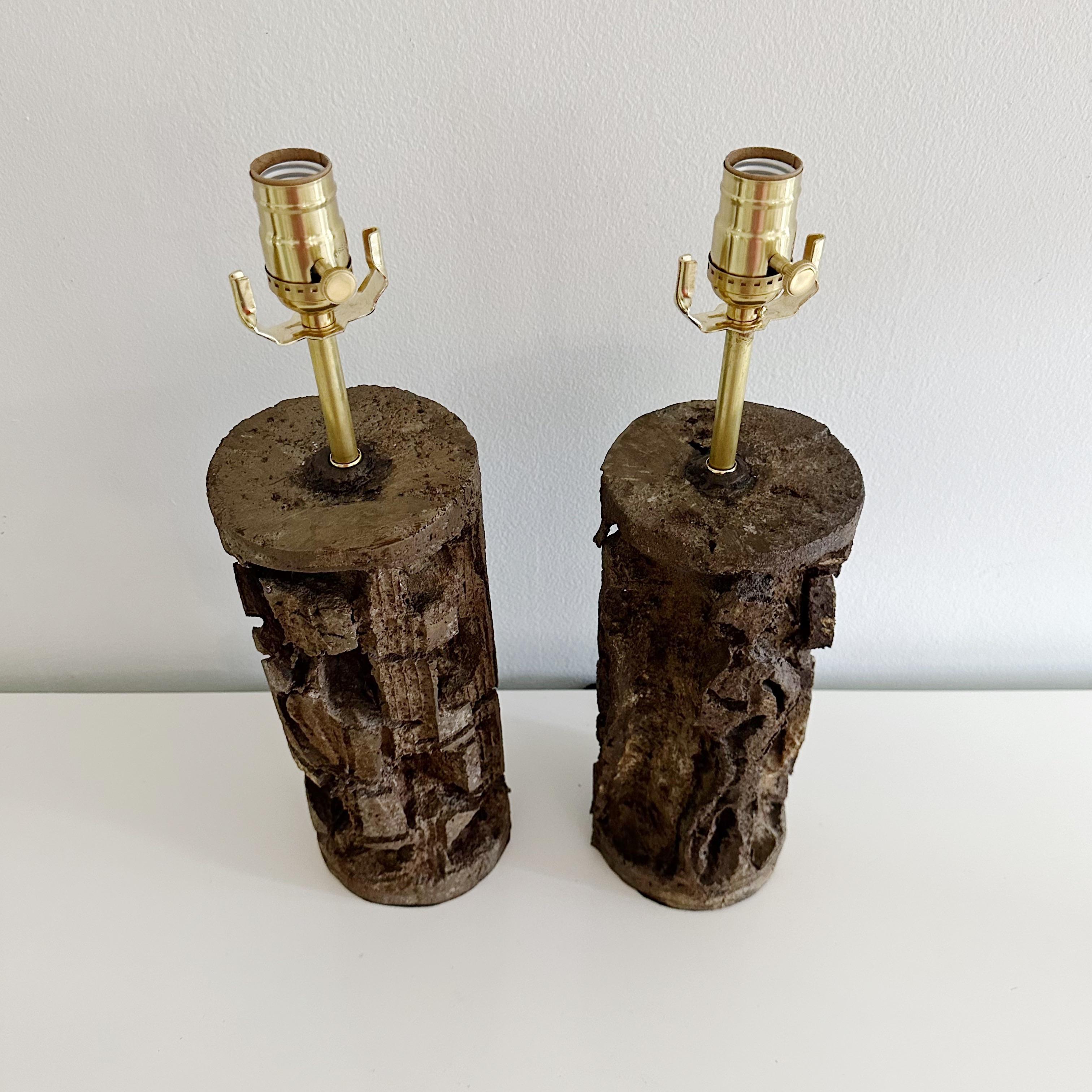 Pair Brutalist Mid Century Lamps Signed
Captivating pair of handmade brutalist lamps. Crafted from sturdy aluminum with a rich bronze-colored finish, each lamp possesses its own unique dimensions due to their handmade nature; one stands a quarter