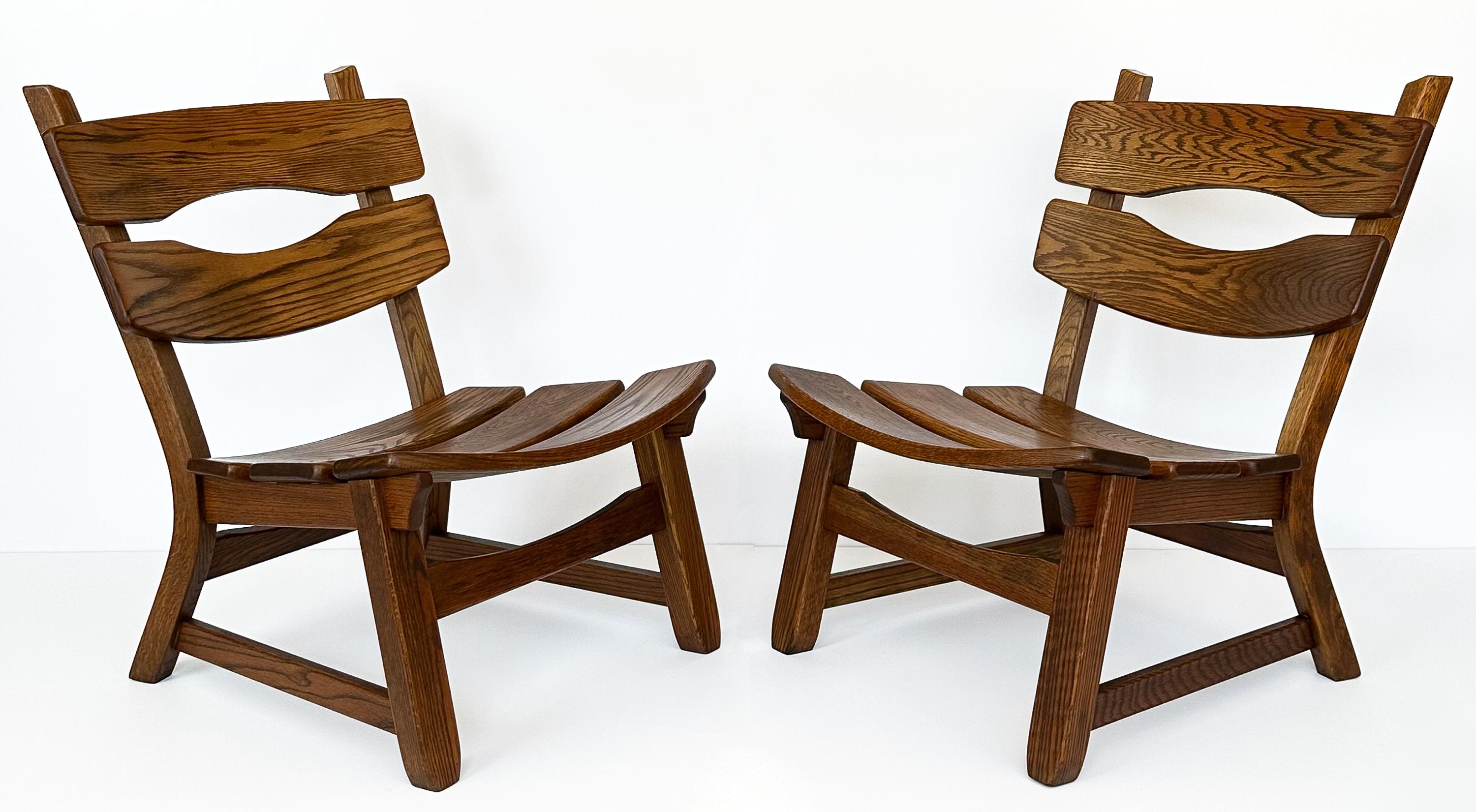 Embrace the bold character of the 1970s with this stunning pair of rustic modernist solid oak lounge chairs by Dittmann & Co for AWA Radboud, hailing from the Netherlands. These armless lounge chairs are substantial in presence, crafted entirely