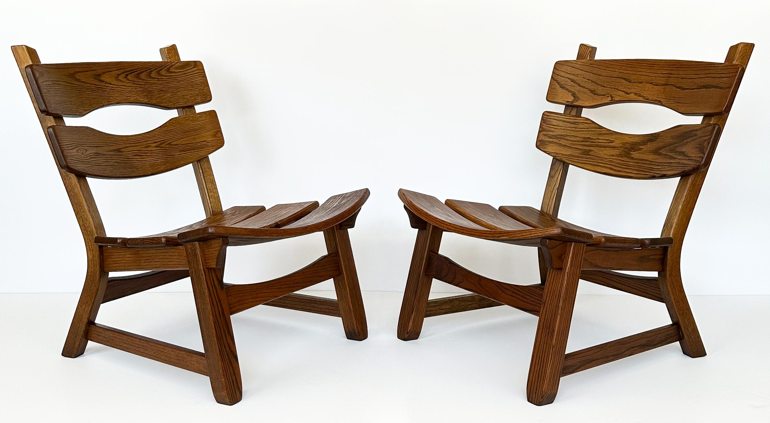 Embrace the bold character of the 1970s with this stunning pair of rustic modernist solid oak lounge chairs by Dittmann & Co for AWA Radboud, hailing from the Netherlands. These armless lounge chairs are substantial in presence, crafted entirely
