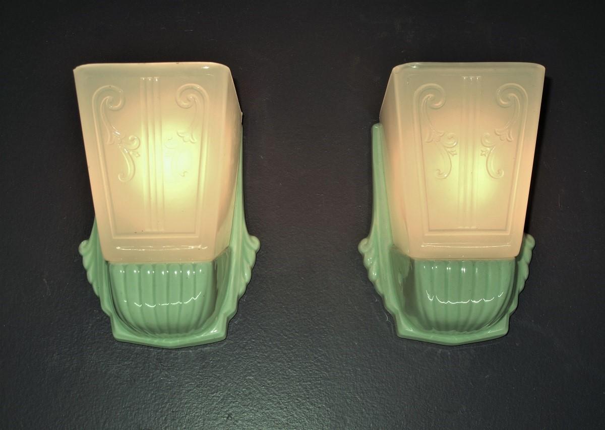 Priced for the pair.
Nicely detailed but restrained deco inspired design on these sconces. Unusual shape to the shades indicate they slide onto a bracket which holds them in place.  Shades are open at the top.
Both the sconce backs and the slip