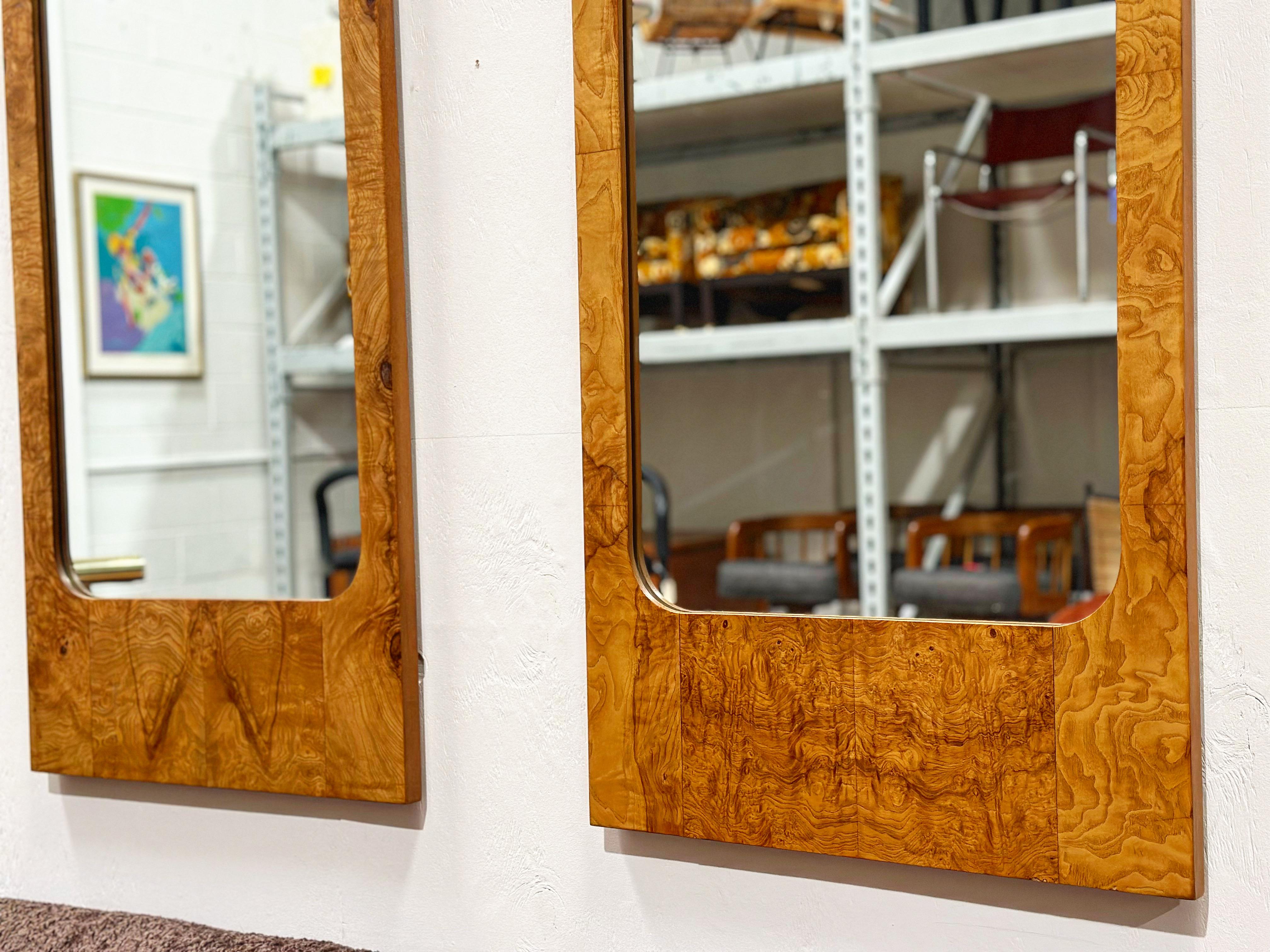 Pair of midcentury burled elm mirrors in the style of Milo Baughman. Sleek rectangular design with gorgeous wood grain throughout makes this wonderful pair the perfect addition to any modern interior. These mirrors were designed for Lane as part of