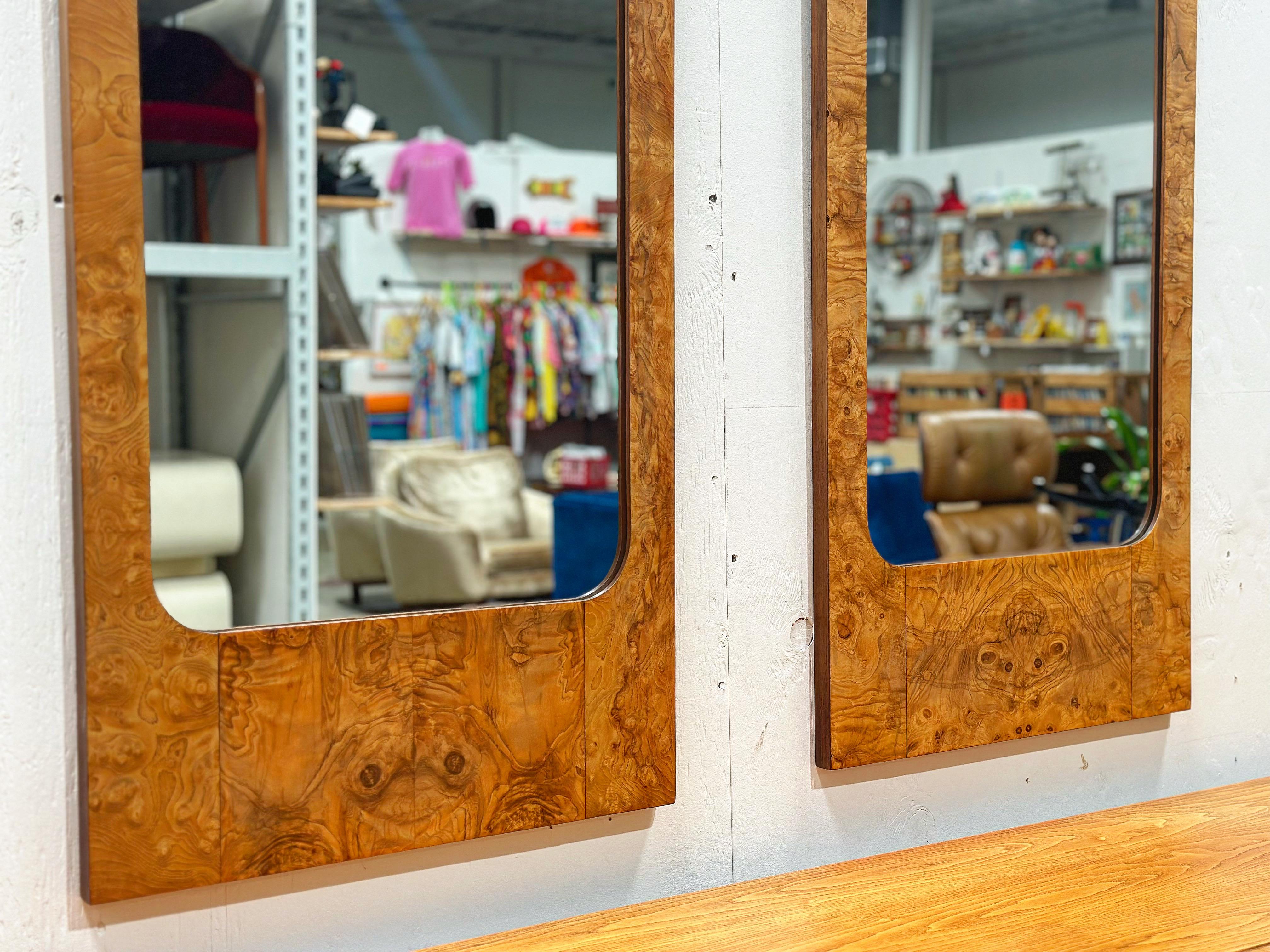 Pair of midcentury burled elm mirrors in the style of Milo Baughman. Sleek rectangular design with gorgeous wood grain throughout makes this wonderful pair the perfect addition to any modern interior. These mirrors were designed for Lane as part of