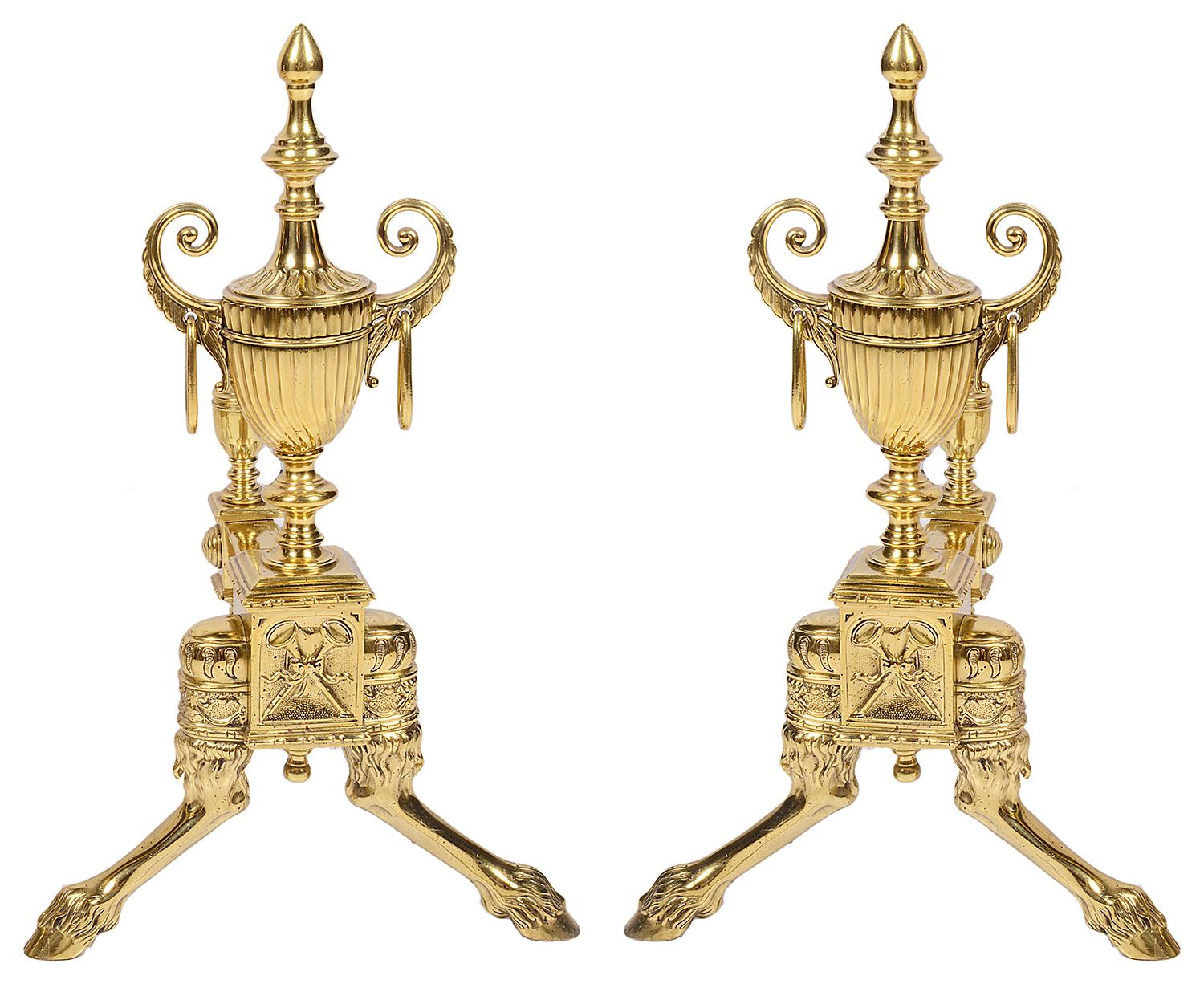 A good quality pair of 19th century brass classical Adam style Andiron / fire dogs. Each having fluted urns with scrolling handles on either side and ring drops, raised on hoof feet.