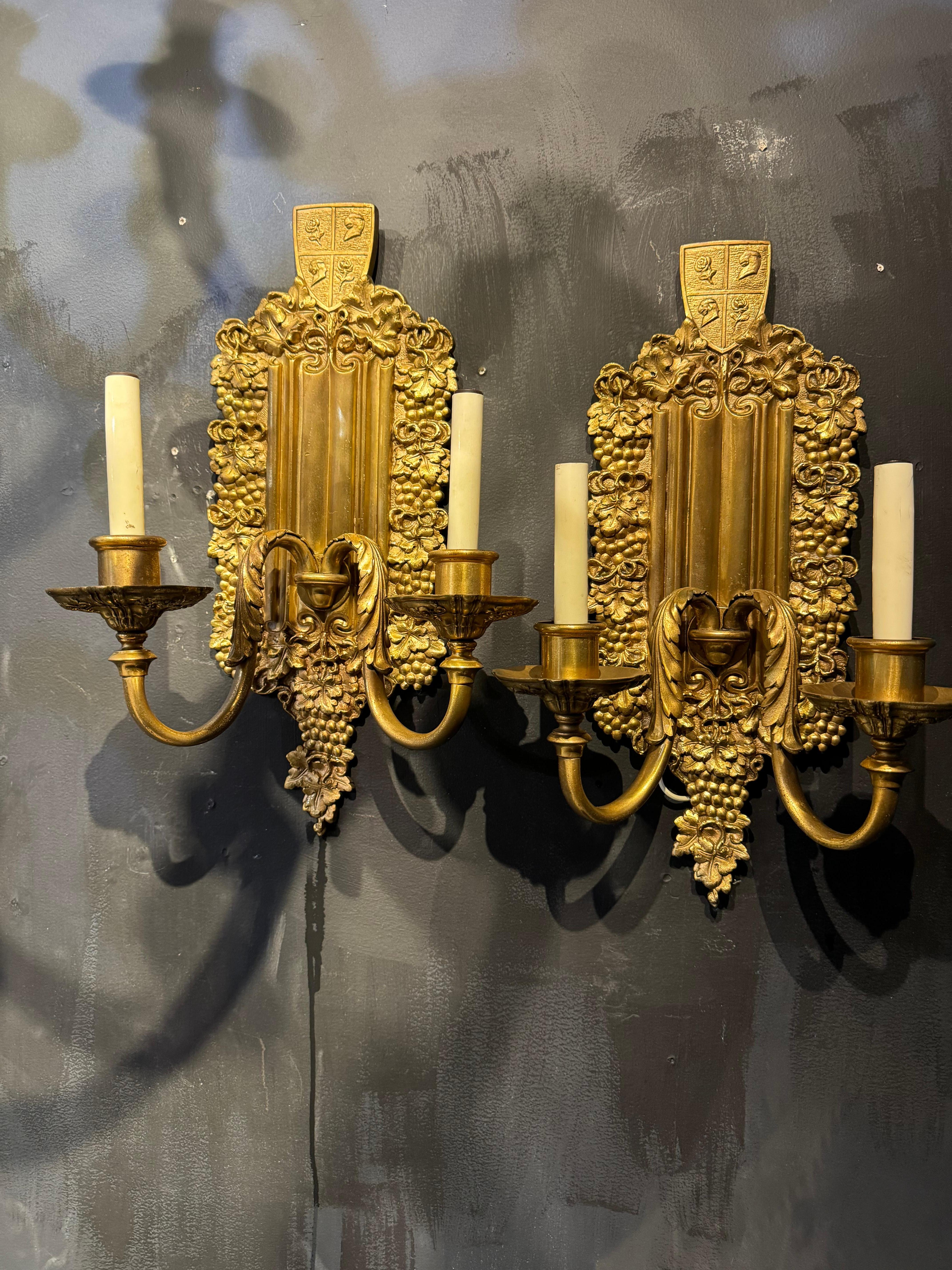 Coppia di appliques a doppia luce in bronzo dorato del 1900 circa con disegno di uva sulla piastra posteriore.