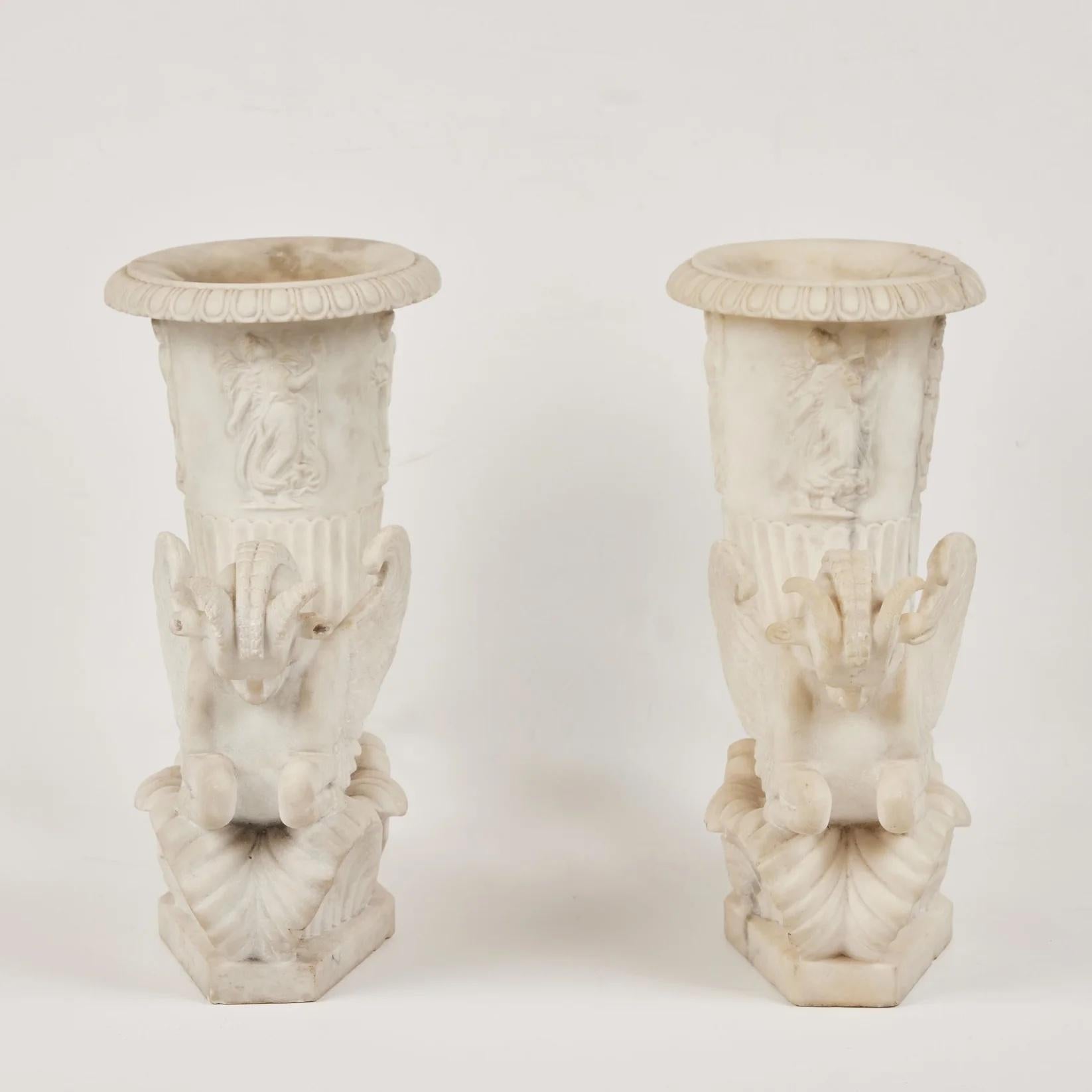 Paire d'hippocampes en marbre de Carrare magnifiquement sculptés à gauche et à droite, avec des ailes et des cornes de bélier. Chaque figure s'élève sur une base de feuilles stylisées et recourbées et se termine par des vases ornés de figures de