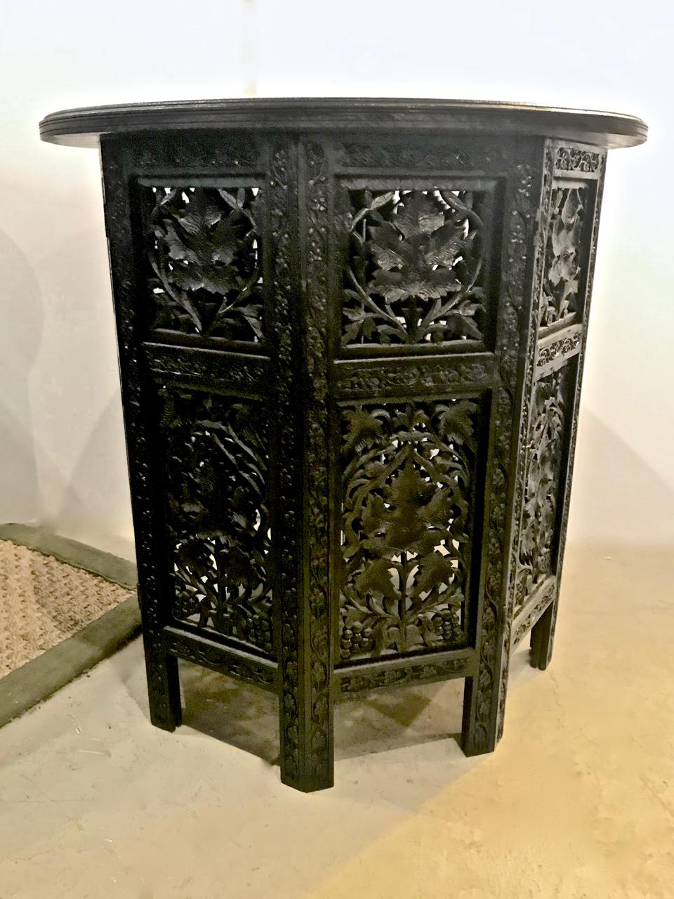 This is a highly decorative pair of mid-20th century Indian carved folding tables. The tables feature finely incised botanical carving and an incised top surface. The incised detailing on one table is partially obscured