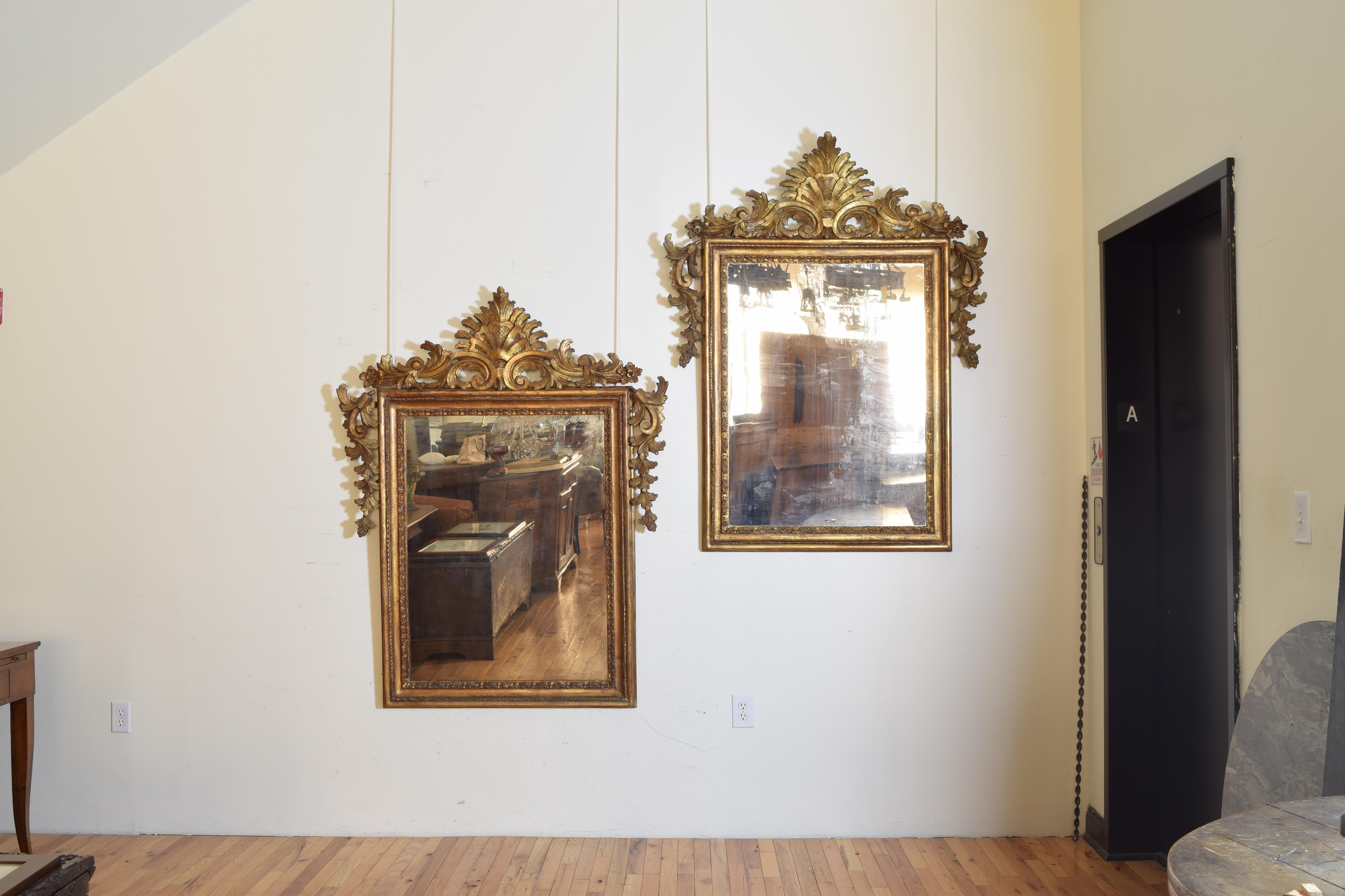 These exceptional and rare mirrors are silver gilt with ambered lacquer and retain their antique mirror plates, the interiors of each mirror a rectangular frame with raised mouldings consisting of carved leaf forms and carved braided ropes, attached