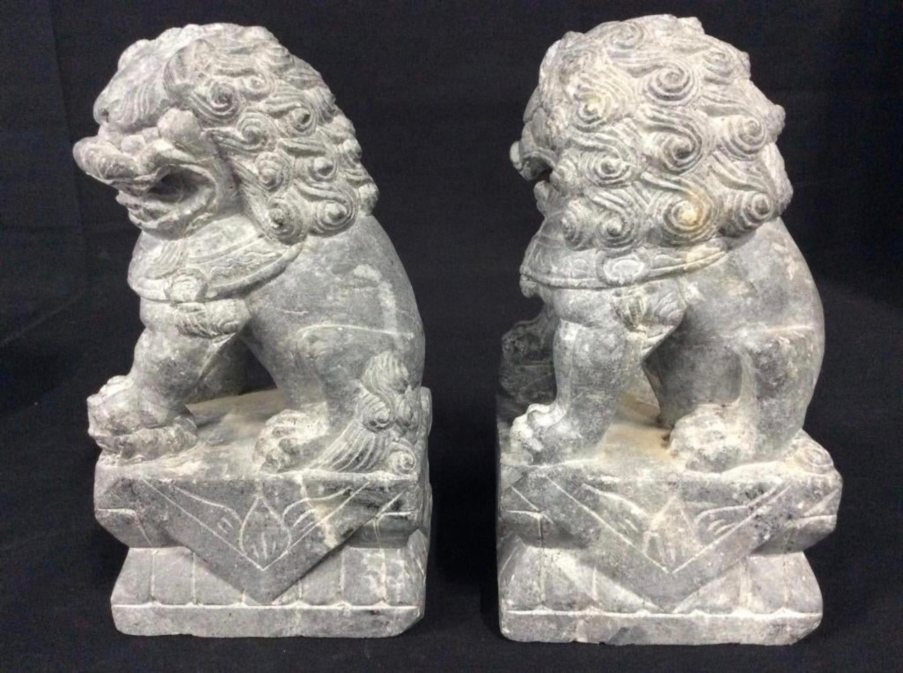 Pair of foo or Fu dogs carved from jade stone. Also known as Chinese foo dogs, Chinese temple dogs, temple lions stone sculpture.
The lions or dogs serve as stone sentinels an iconic gatekeeper seen throughout Asia. Traditional symbol of protection,