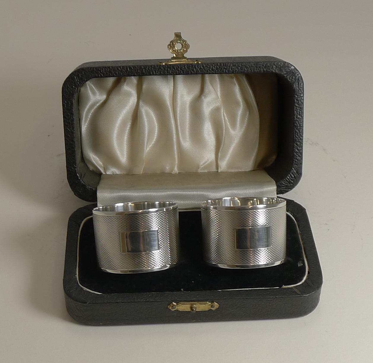 A very smart pair of quality napkin rings made from a good gauge of English sterling silver with an all - over engine turned decoration with a vacant rectangular cartouche to the front of each.

Both are fully hallmarked for Sheffield 1945