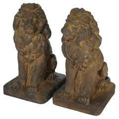 Paire de statues classiques de lion assis en pierre dure moulée en finition bronze, 21e siècle