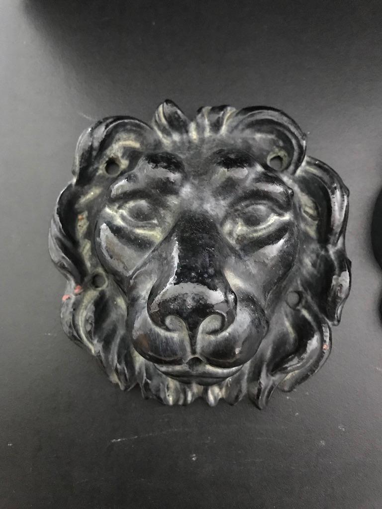 A great looking pair of black painted cast iron lion heads meant to be mounted on a wall as ornaments or as wall fountains. The mouths are drilled to spout water, if desired. These make handsome decorations attached directly to an interior or