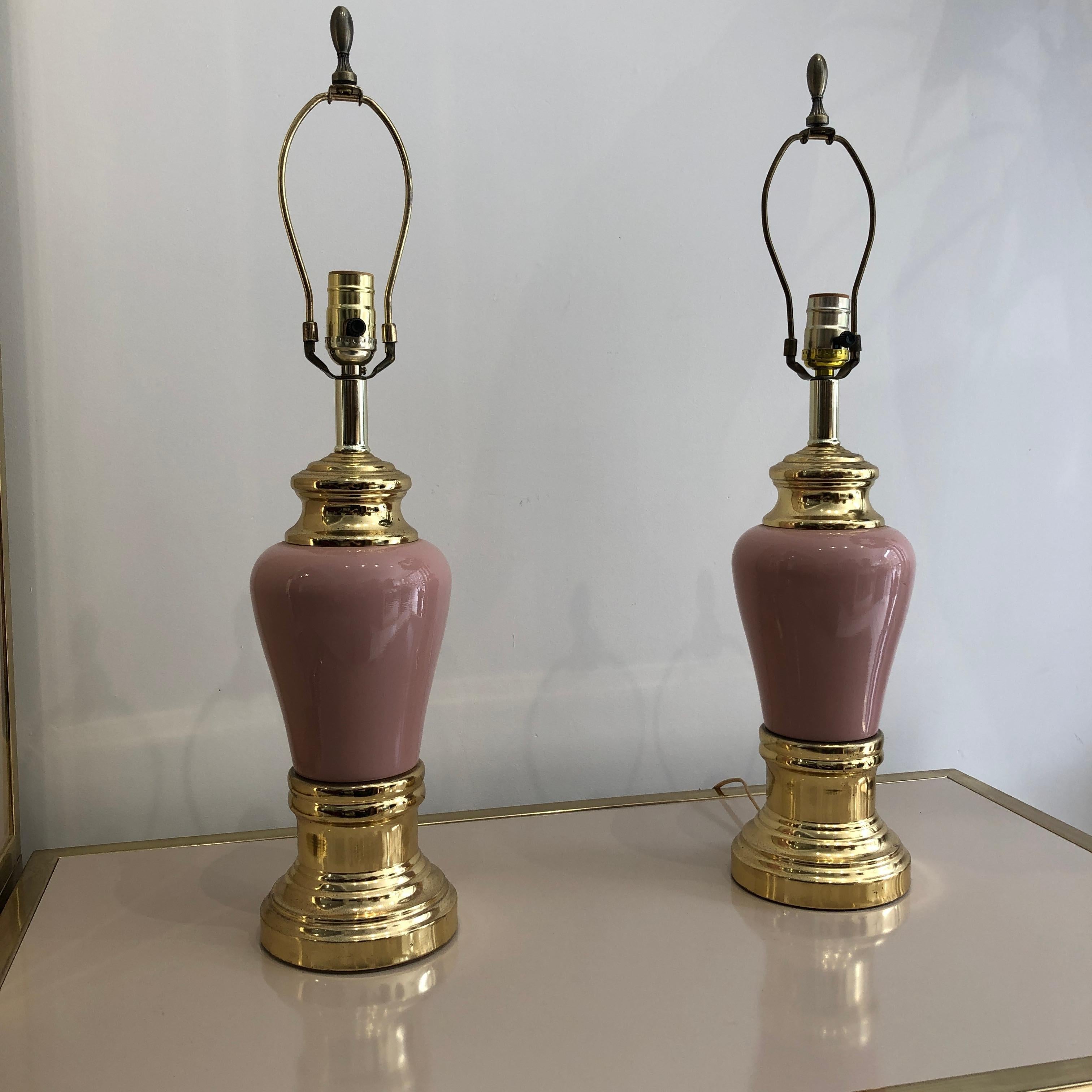 Lovely pair of ceramic table lamps in millennial dust pink body and brass golden base. The lamps have a sculpture like jewellery element feel giving it a glamours look. 
They would look amazing with the right shades and in a modern or vintage