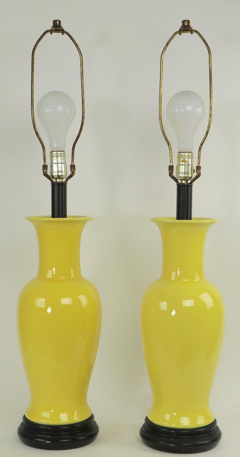 Fun pair of 1970s yellow ceramic table lamps, in excellent, original and working condition. Perfect for sunroom, patio or to brighten up any room, offered and priced as a pair, shades not included in lot. Lamps attributed to Warren Kessler,