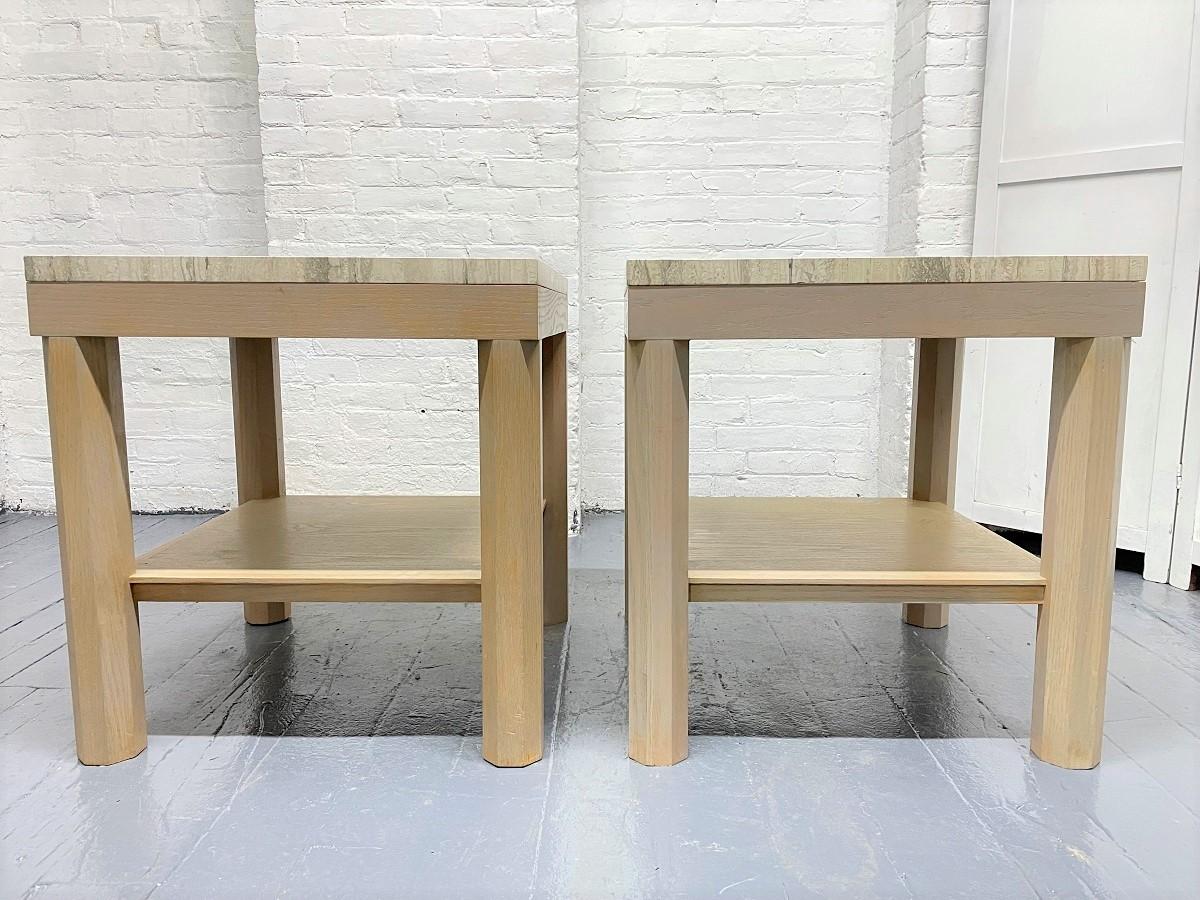 Pair of cerused oak and travertine top side tables. The legs have an octagonal shape and the tables have a lower shelf. The travertine is one inch thick.