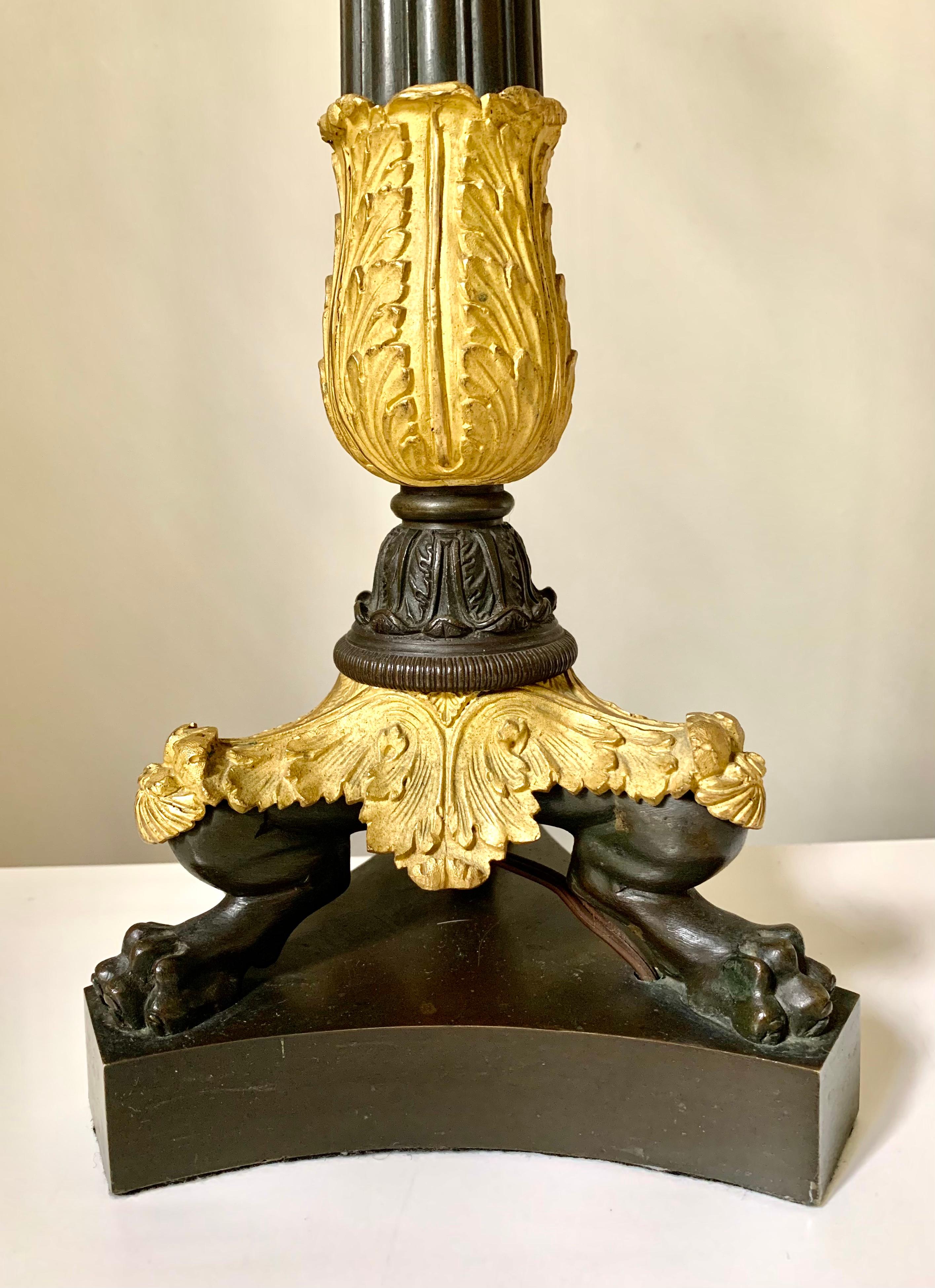 Fine quality pair of Charles X period gilt and patinated bronze candelabra lamps. Each having a central hand chiselled gilt bronze candle stem decorated with quatrefoil four leaf clover elements against a hand hammered background, topped by stylized