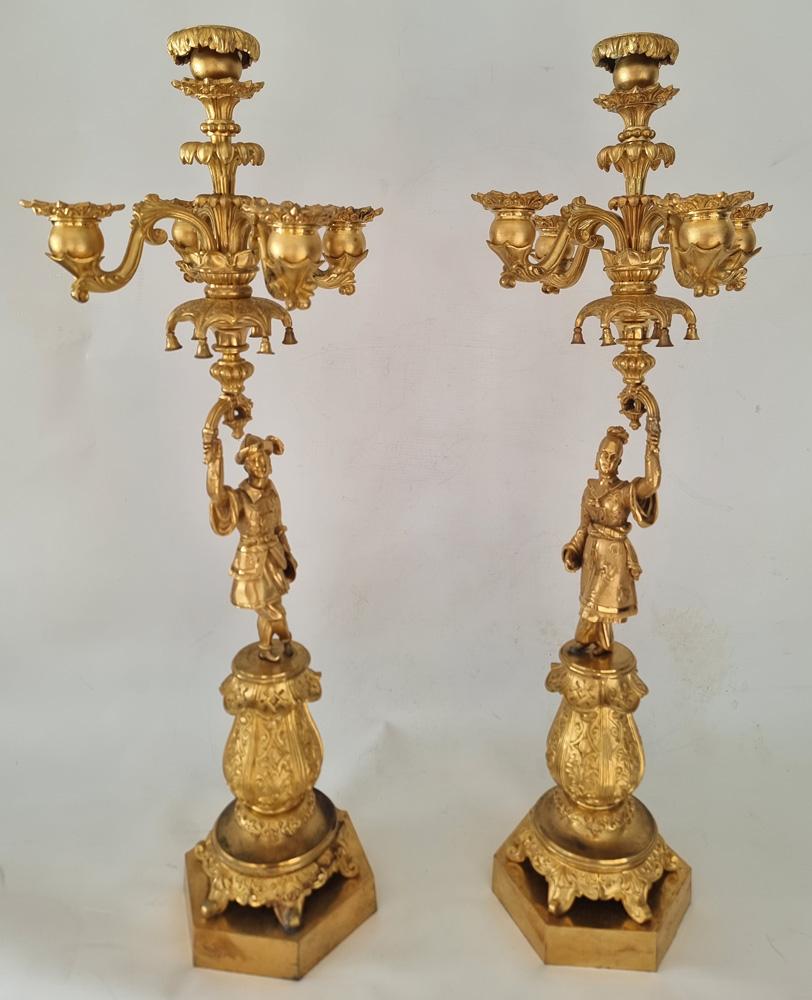 Un'attraente coppia di candelabri in ormolu del periodo Charles X in stile chinoiserie francese. Su basi a sei lati con steli a sei lati decorati con fiori. Su uno stelo si erge la figura di un gentiluomo cinese in abiti fluenti, stivali, un