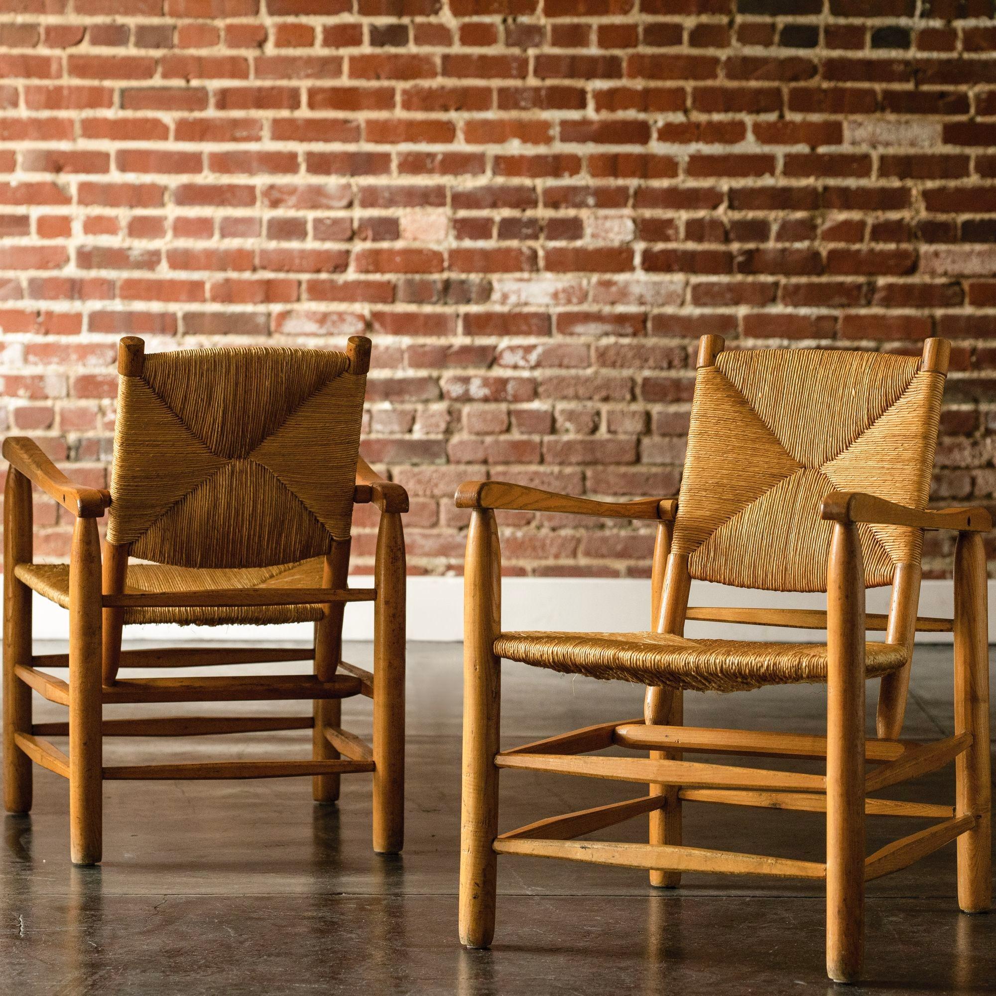 A pair of the iconic and beautiful Perriand Model No. 21 armchairs in oak with rush seats for the 