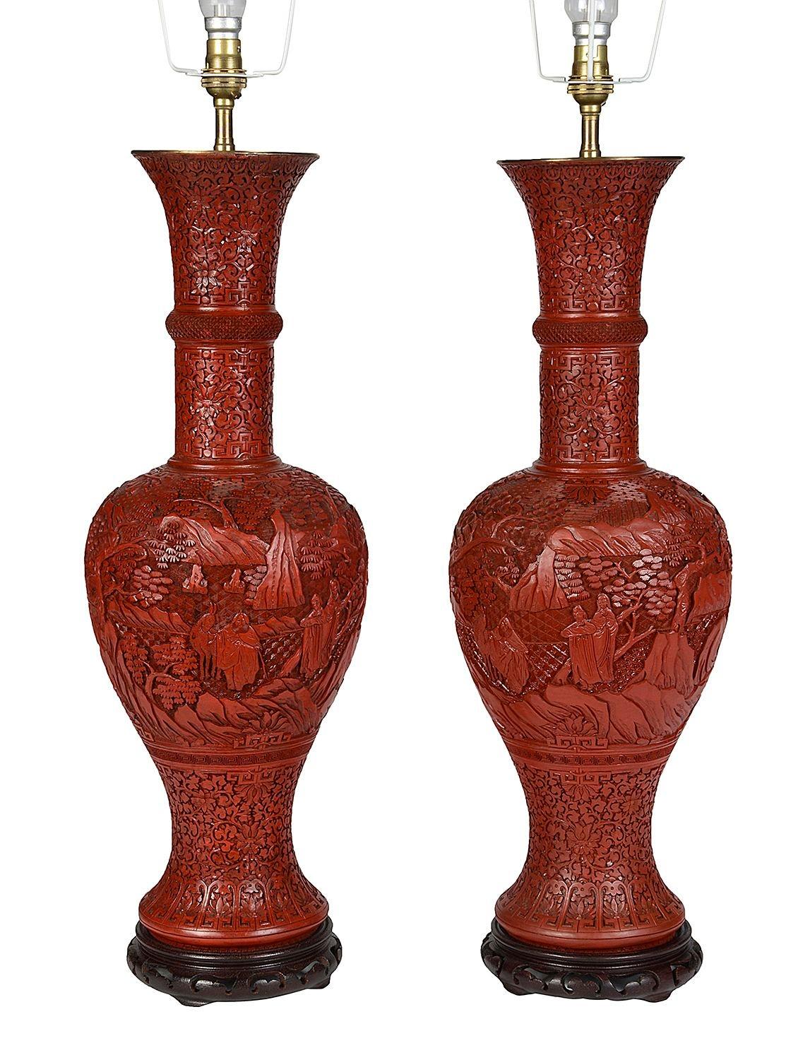 A very decorative and good quality pair of 18th Century style Chinese Cinnabar lacquer vases / lamps. Each with scrolling foliate and classical motif decoration to the ground and traditional scenes of various couriers, tradesmen in the gardens, with