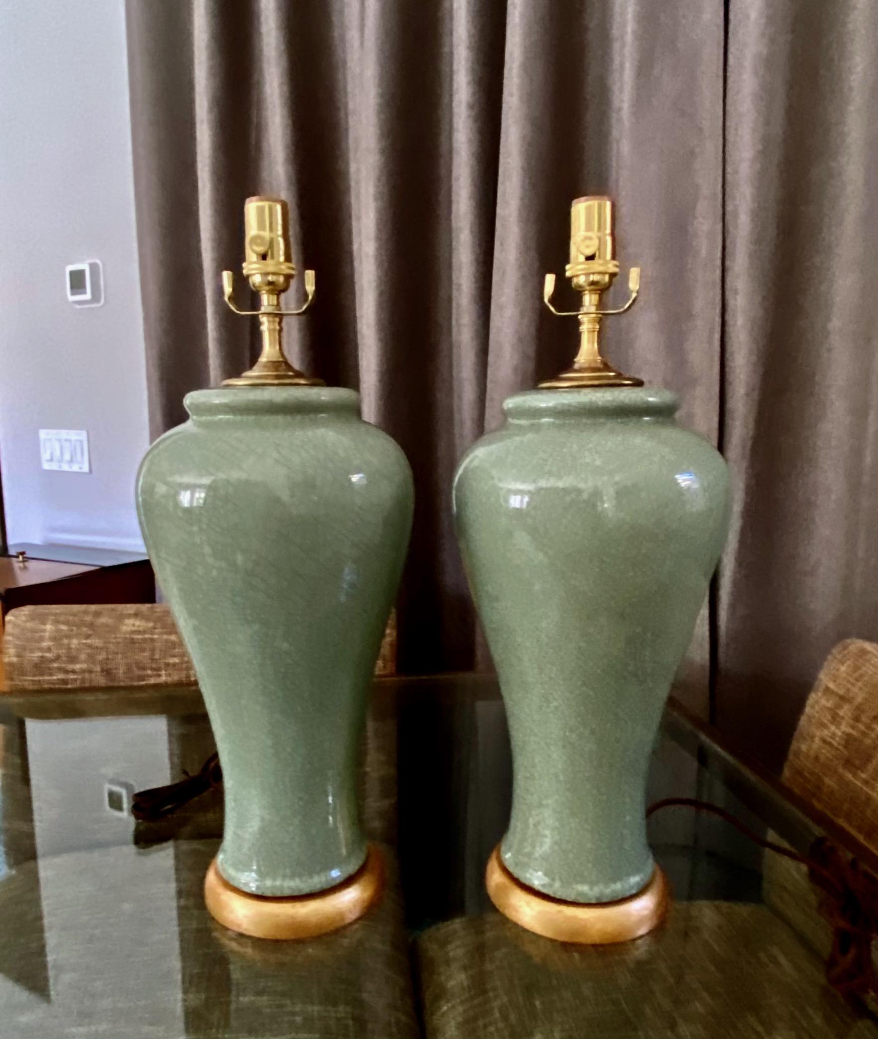 Pair of Chinese celadon green crackle porcelain baluster form vase table lamp. Mounted on gilt turned wood lamp base. Newly wired with new 3 way socket and fittings. Porcelain vase portion is 16