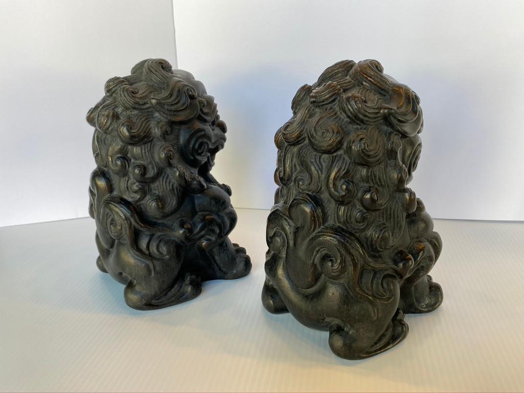 Pair of Chinese lions completely hand carved out of solid bamboo root. They would make excellent decorative book ends or guardian door stops. Sweet faces with a smile and curly hair depicted