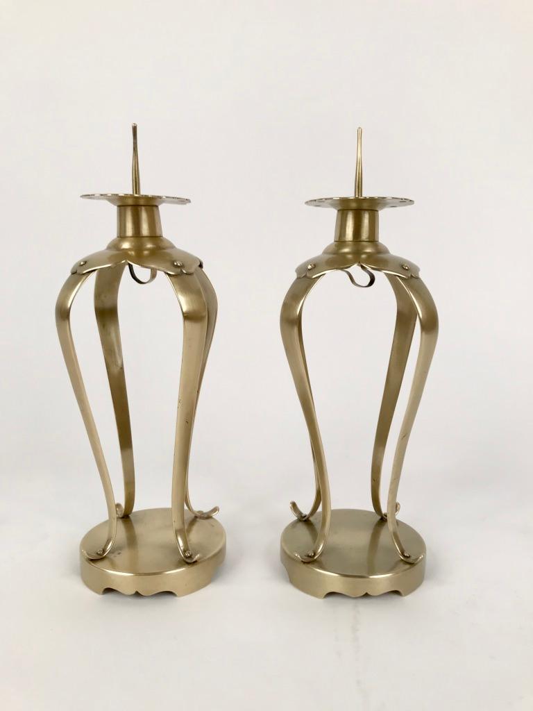 A fine pair of small beautifully made Japanese brass candlesticks with delicate silhouettes. The four curving legs on a round base supporting the pricket candle holders. A very appealing form that will work with mid-century or antique decor. Perfect