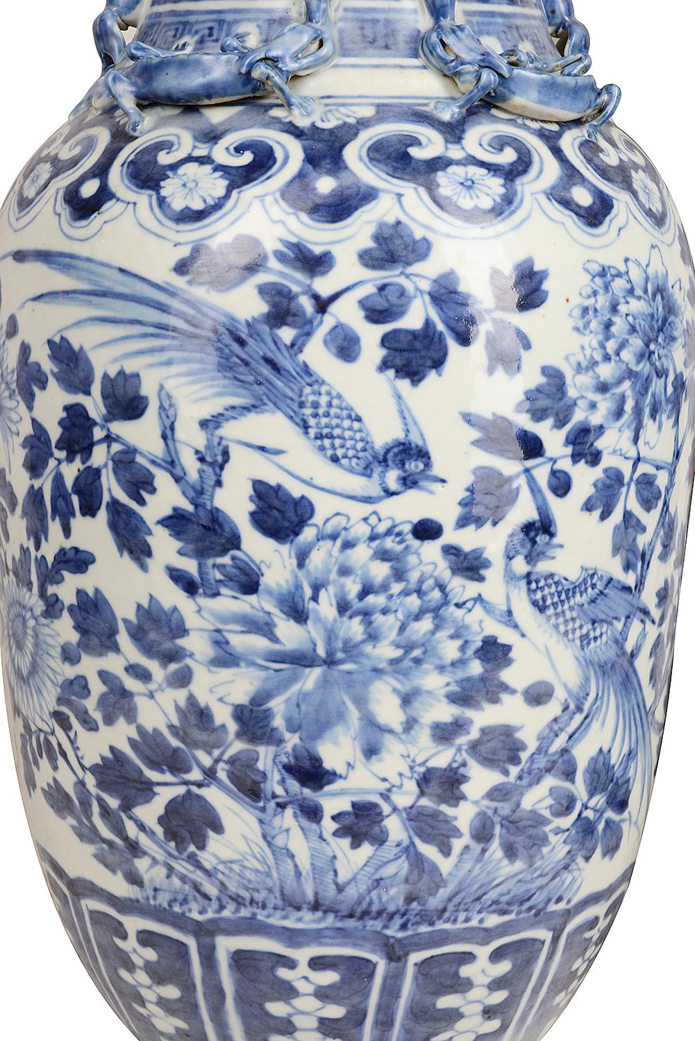 A good quality pair of 19th century Chinese blue and white vases, each with exotic birds amongst leaves and flowers, lizard mounts to the neck and classical motifs to the neck and base.