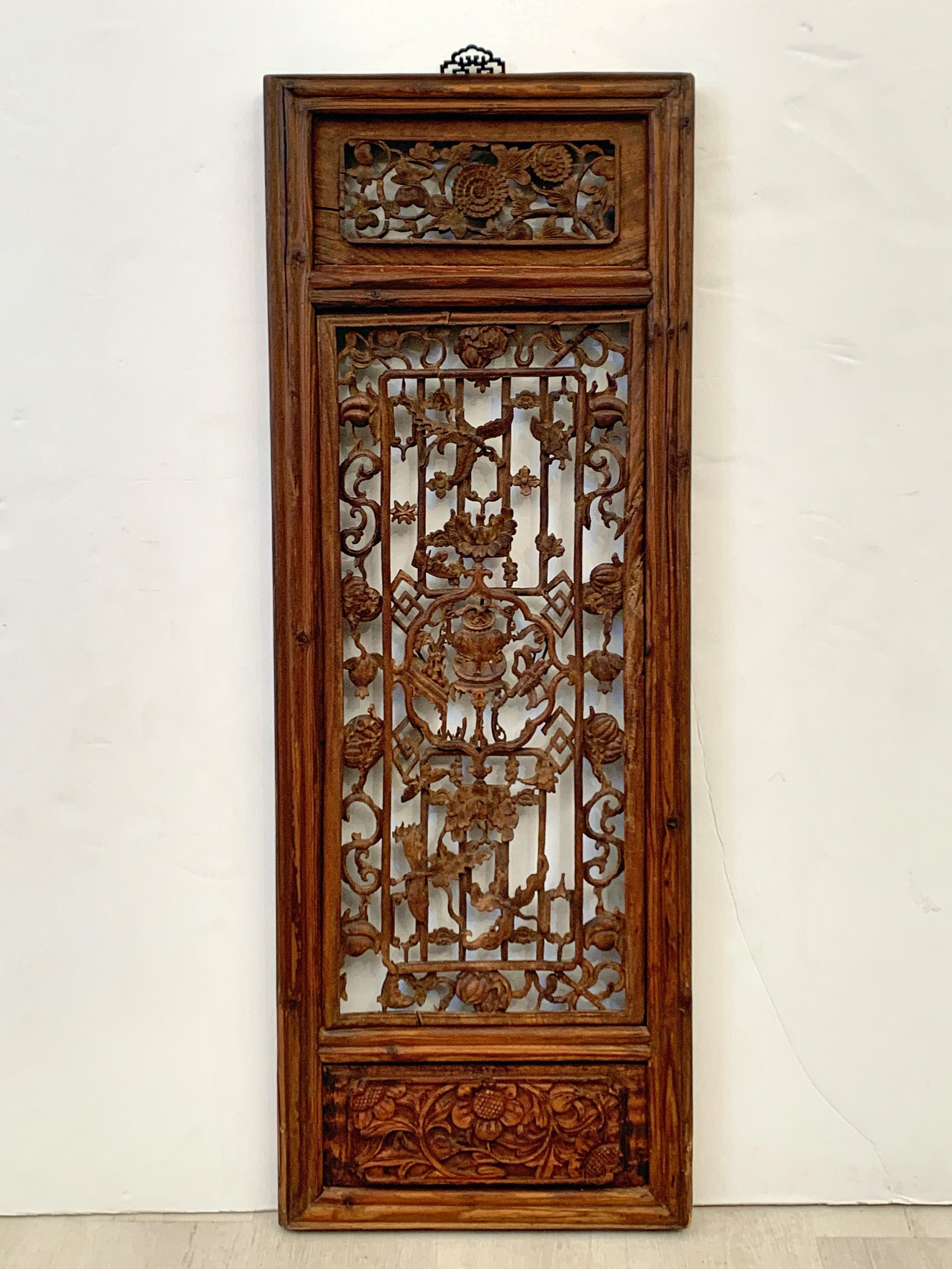 A very well carved pair of 18th century Chinese Qing Dynasty carved camphor wood window screen panels.

The camphor wood panels finely carved and pierced, and joined, featuring auspicious motifs throughout. The panels featuring intricate and