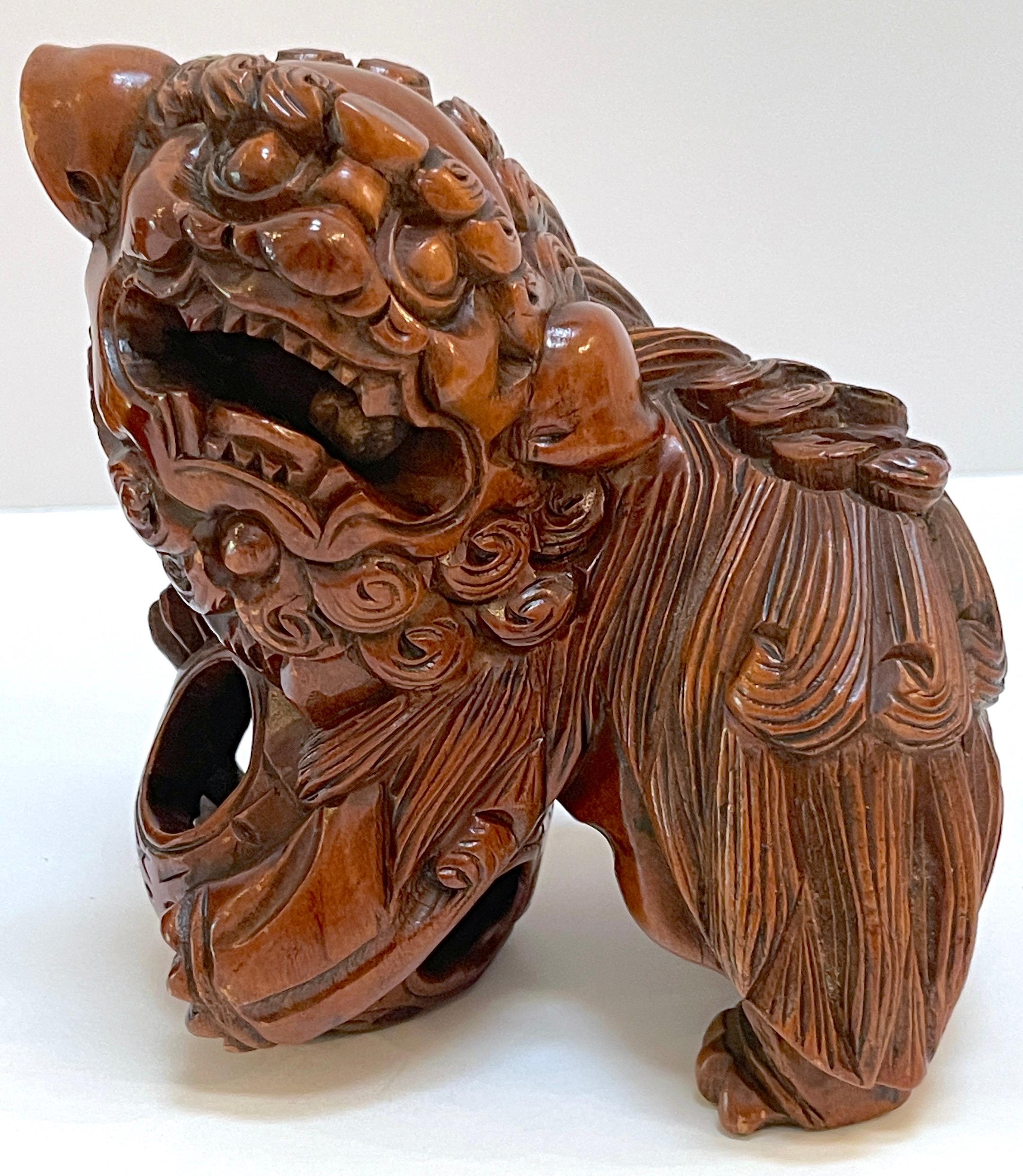 20ième siècle Paire de chiens Foo chinois en bois dur sculpté avec perles roulantes et boules de puzzle  en vente