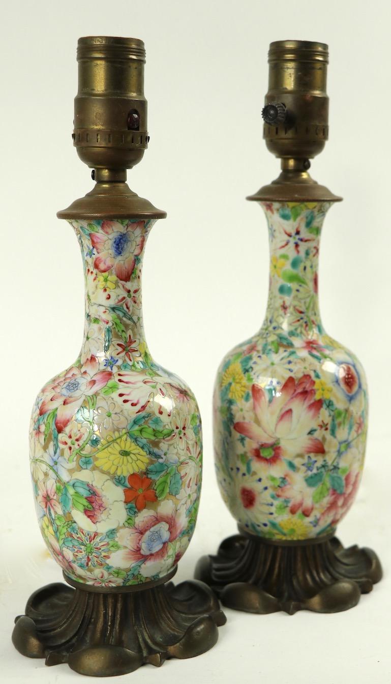 Diminutive Chinese vases mounted as lamps on decorative cast bronze bases. Both are in good working condition, one on off switch has been replaced, diameter of ceramic vase 3 inches. Priced and offered as a pair.