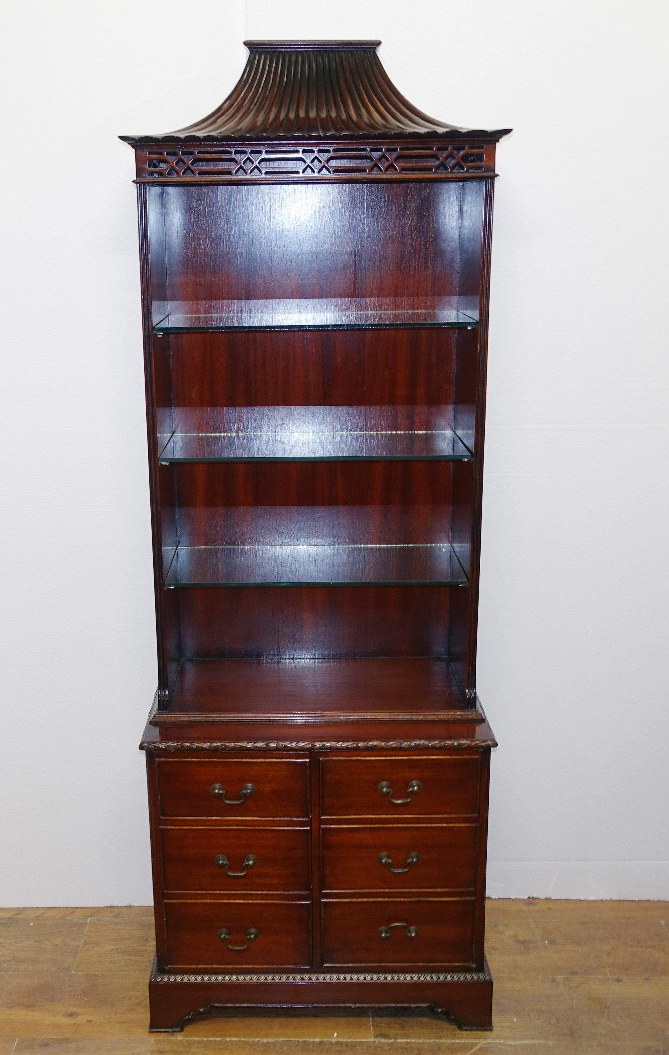 Elegant pair of antique bookcases in the Chinese Chippendale manner
Both are surmounted by the pagoda tops with intricate fret work below
Hand crafted from mahogany they feature adjustable glass shelving The bottom sections feature 8 bookcases to