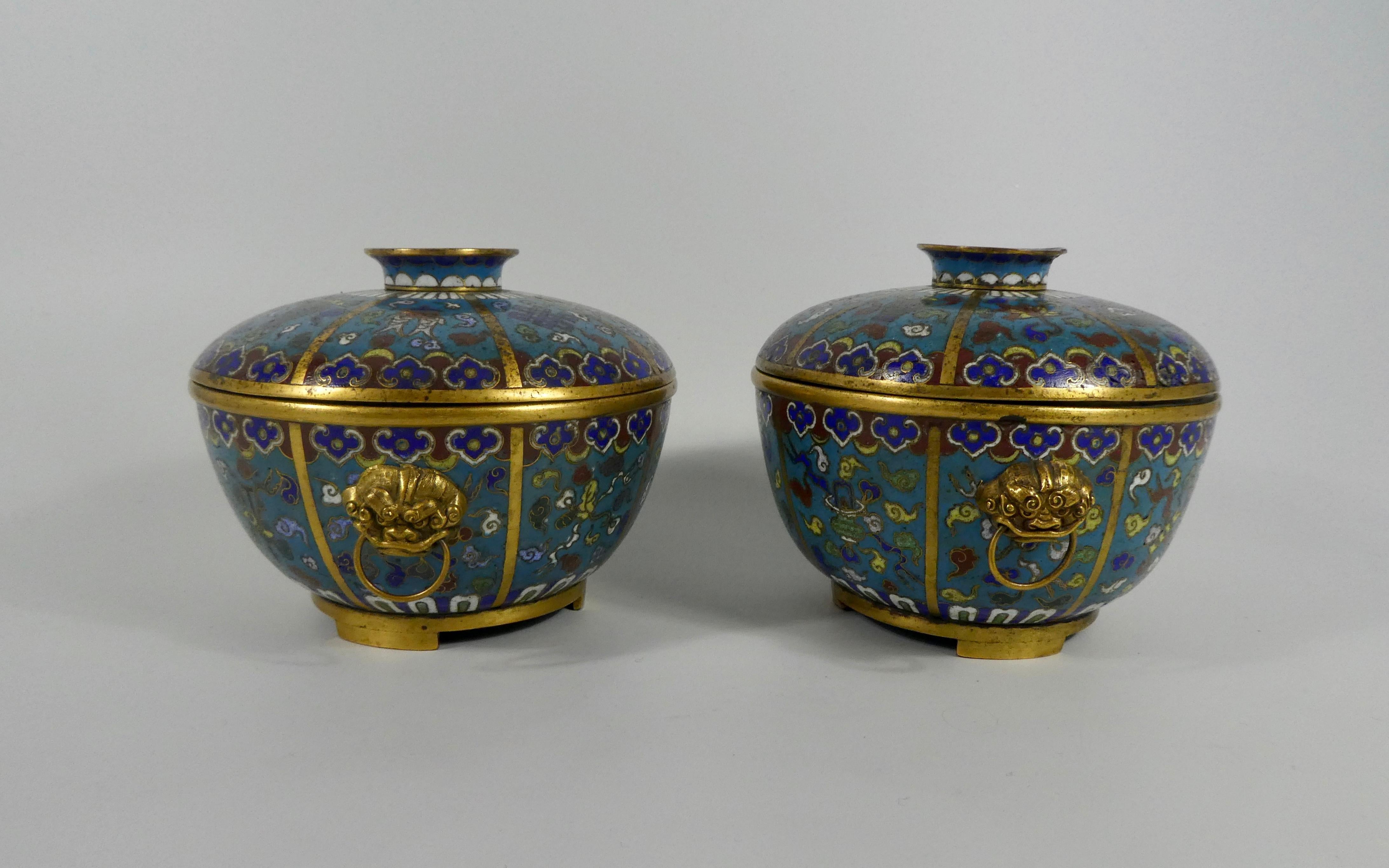Pair of Chinese cloisonne bowls and covers, 19th century, Qing dynasty. Both bowls enameled with the ‘Eight Buddhistic Symbols’, in gilt wires, on a turquoise ground, within gilt metal panels, and continuous ruyi head, and lappet borders. Having