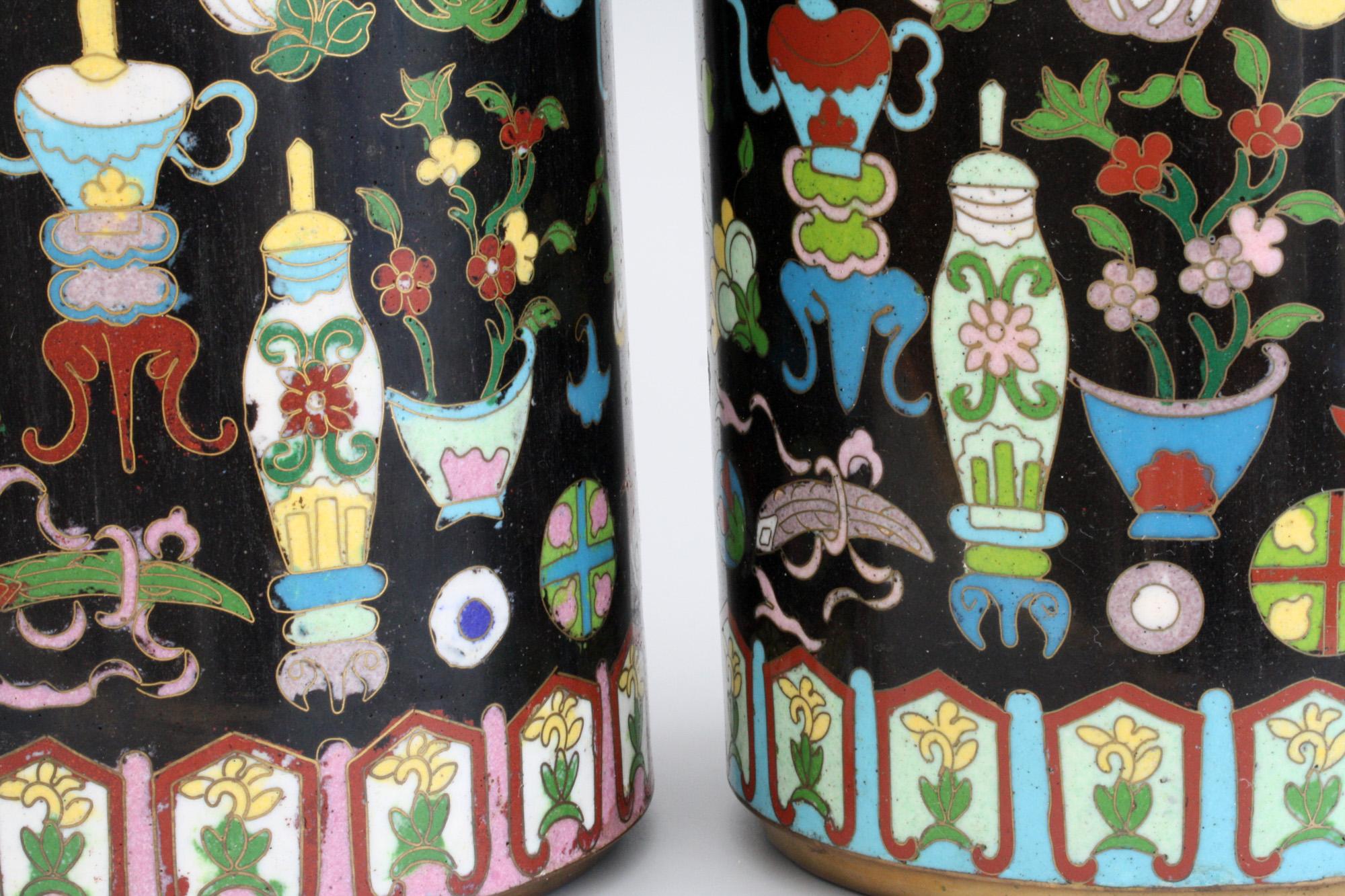 An exceptional and stunning pair cylindrical Chinese cloisonné enamel sleeve vases dating from the early 20th century, probably late Qing. The tall pair of vases are brightly decorated in colored enamels on black grounds decorated with scholars and