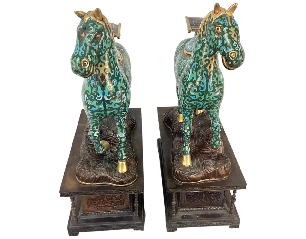Pair of 19th century Chinese Cloisonné enamel caparison horse-form censers (incense burners) on patinated metal bases. Horses are brightly colored blue and turquoise with gold accents.