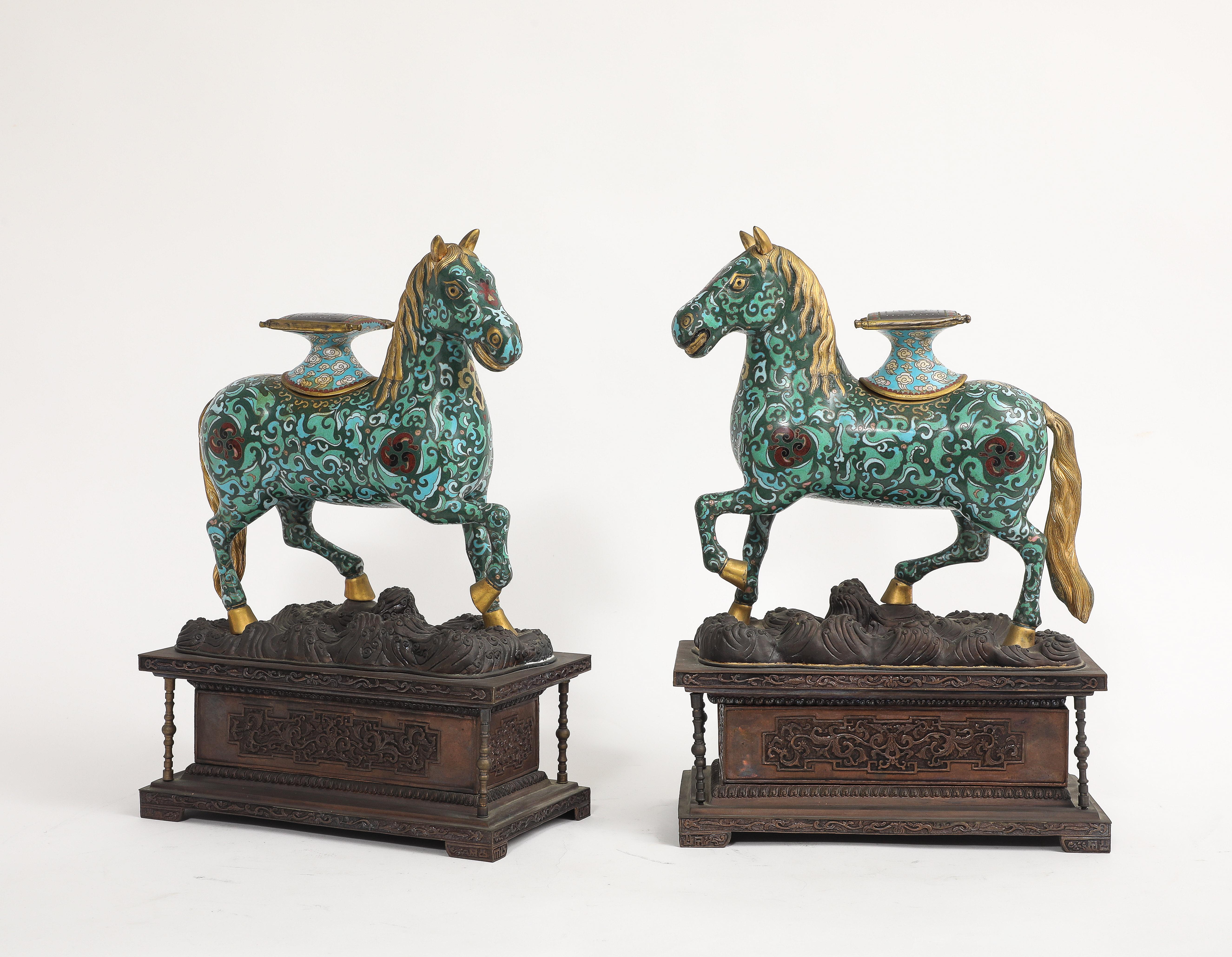 Paire de chevaux chinois en émail cloisonné sur des bases en bronze patiné avec selles amovibles

Cette paire de chevaux en émail cloisonné est modélisée dans une posture animée, chaque figure s'avançant sur des bases sculptées en forme de nuage