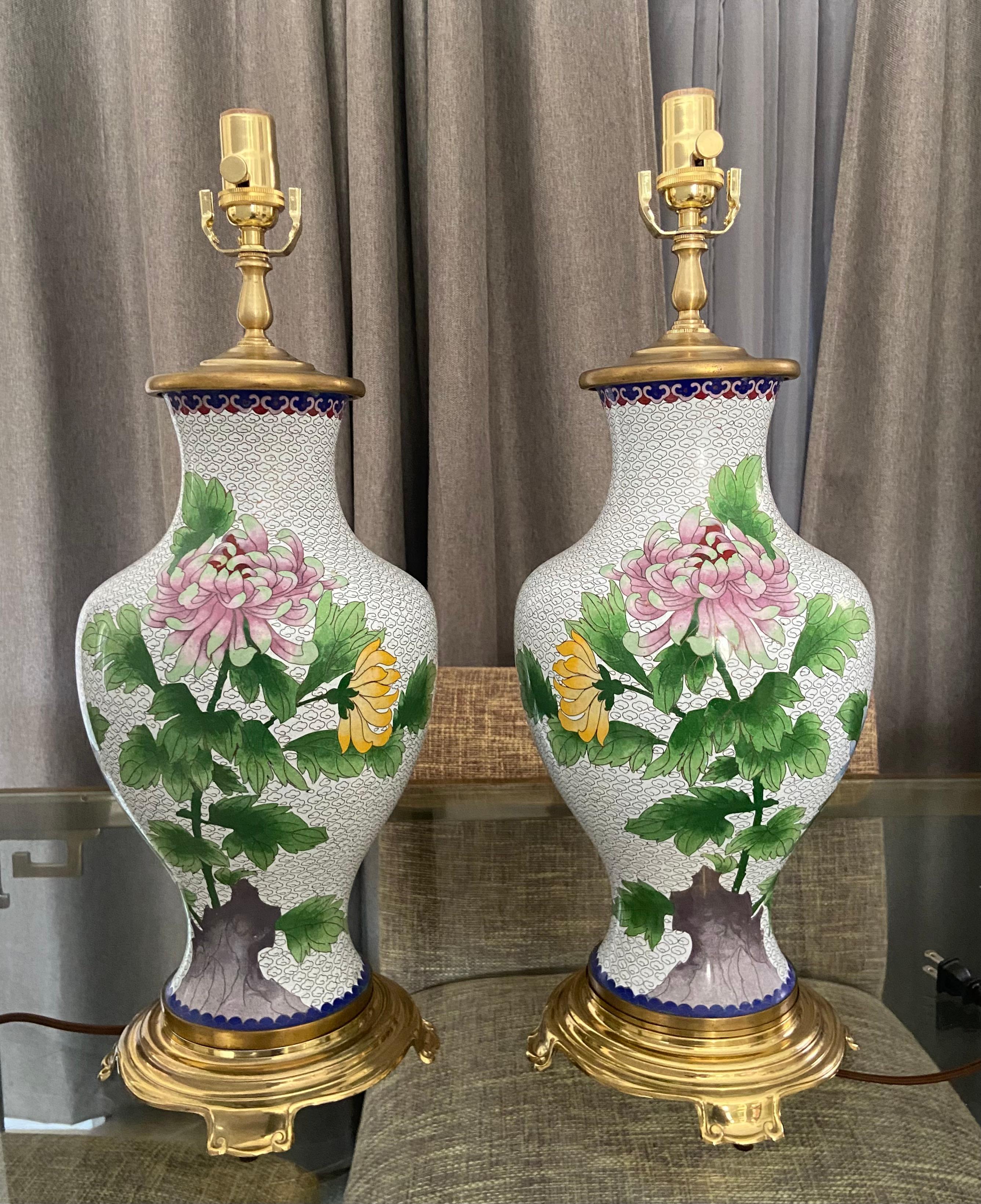 Pair of early 20th century Chinese Cloisonné floral motif table lamps mounted on custom brass bases. Rewired with new 3-way sockets and rayon cords. Height of Cloisonné vase 20