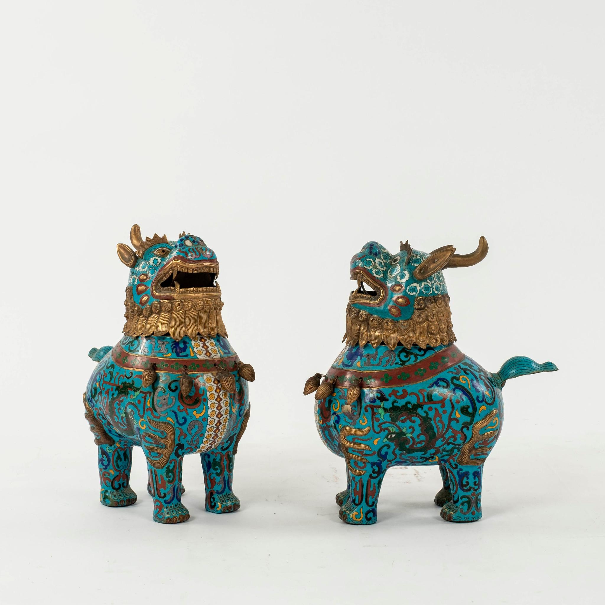 Copper base cloisonné Fu Dogs made for Chinese export with gilded, mane, ears and accents. This pair from 1910s or earlier.