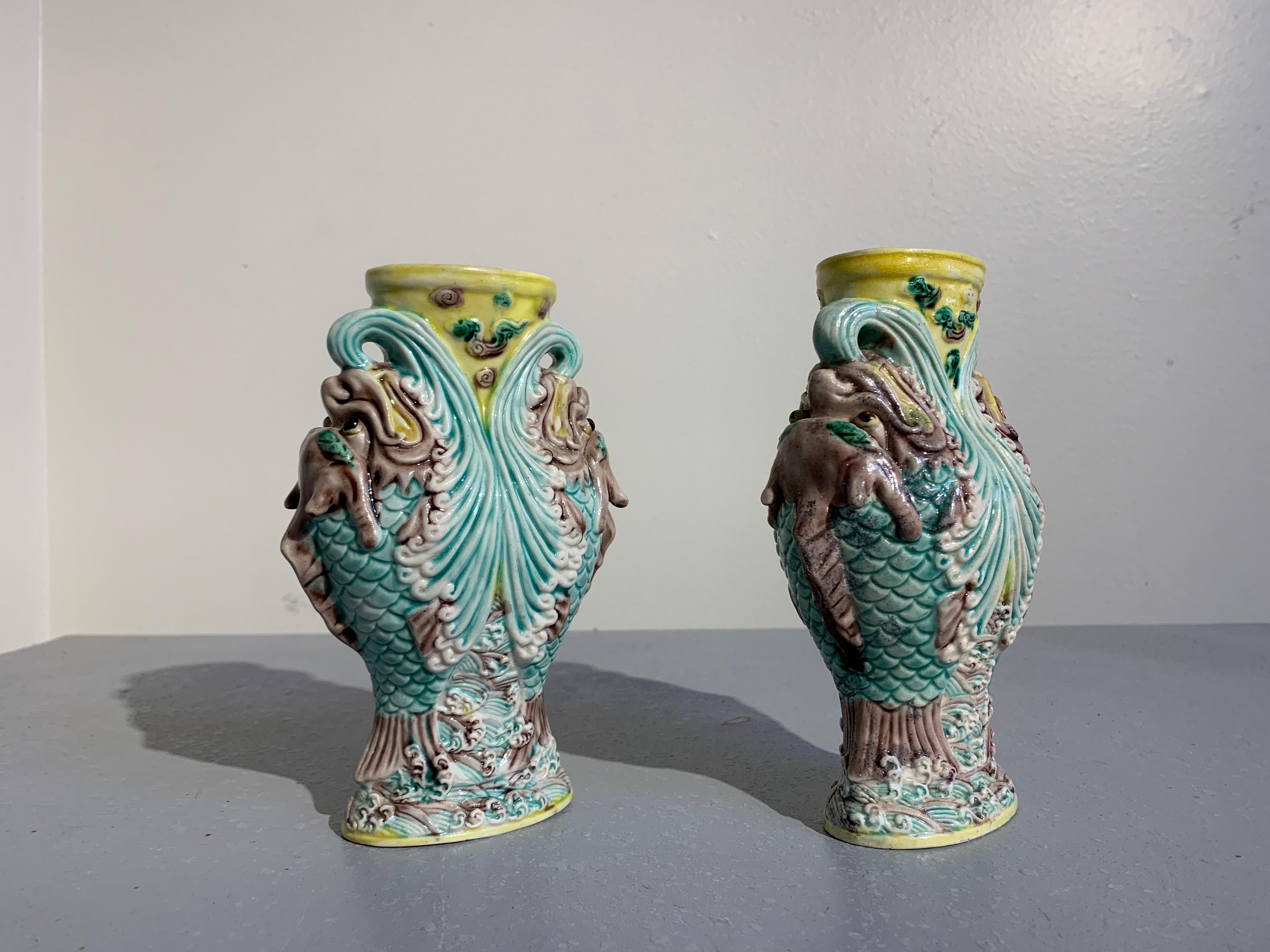 Ein fantastisches Paar chinesischer geformter und glasierter Biskuitporzellanvasen mit springendem Drachenfisch oder Makara, späte Qing-Dynastie, um 1900.
Die Vasen in Balusterform sind jeweils mit einem Hochrelief versehen, auf dem ein Paar