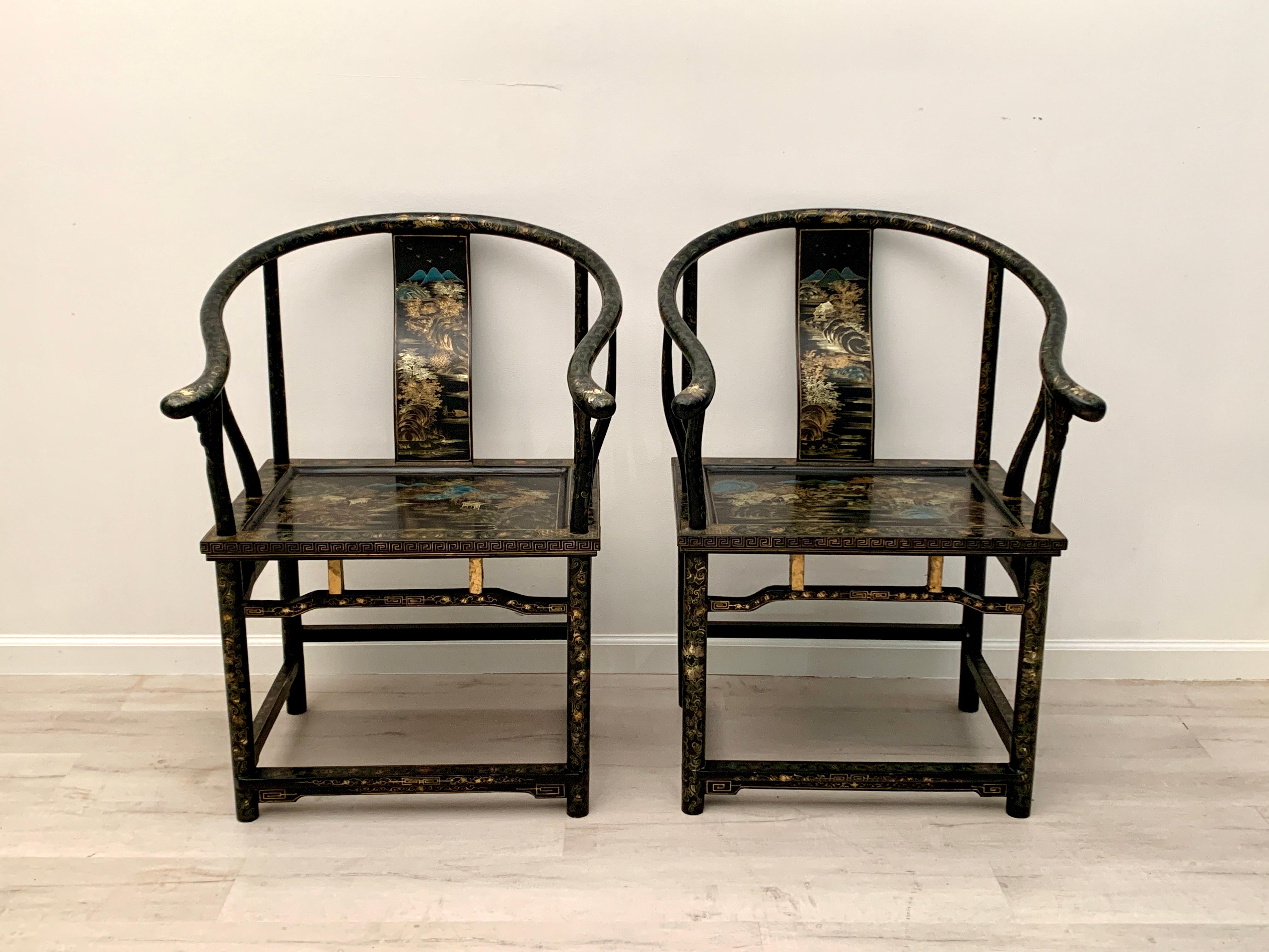 An elegant and exquisite pair of Chinese export black lacquer, gilt and polychrome painted horseshoe back chairs, mid 20th century, China.

The black lacquer chairs of horseshoe back form, with an elegantly curved backrail sloping downwards to