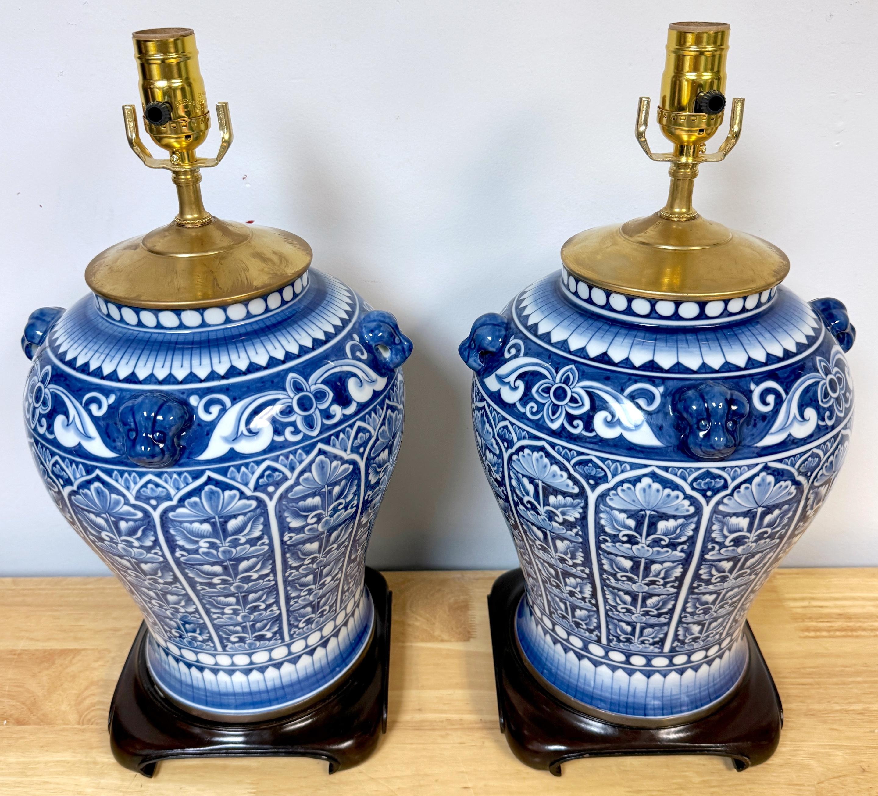 Coppia di medaglioni in porcellana cinese blu e bianca da esportazione con fiori esotici e cani da caccia, Cina, XX secolo 

Questa straordinaria coppia di lampade cinesi da esportazione in porcellana blu e bianca cattura l'eleganza senza tempo
