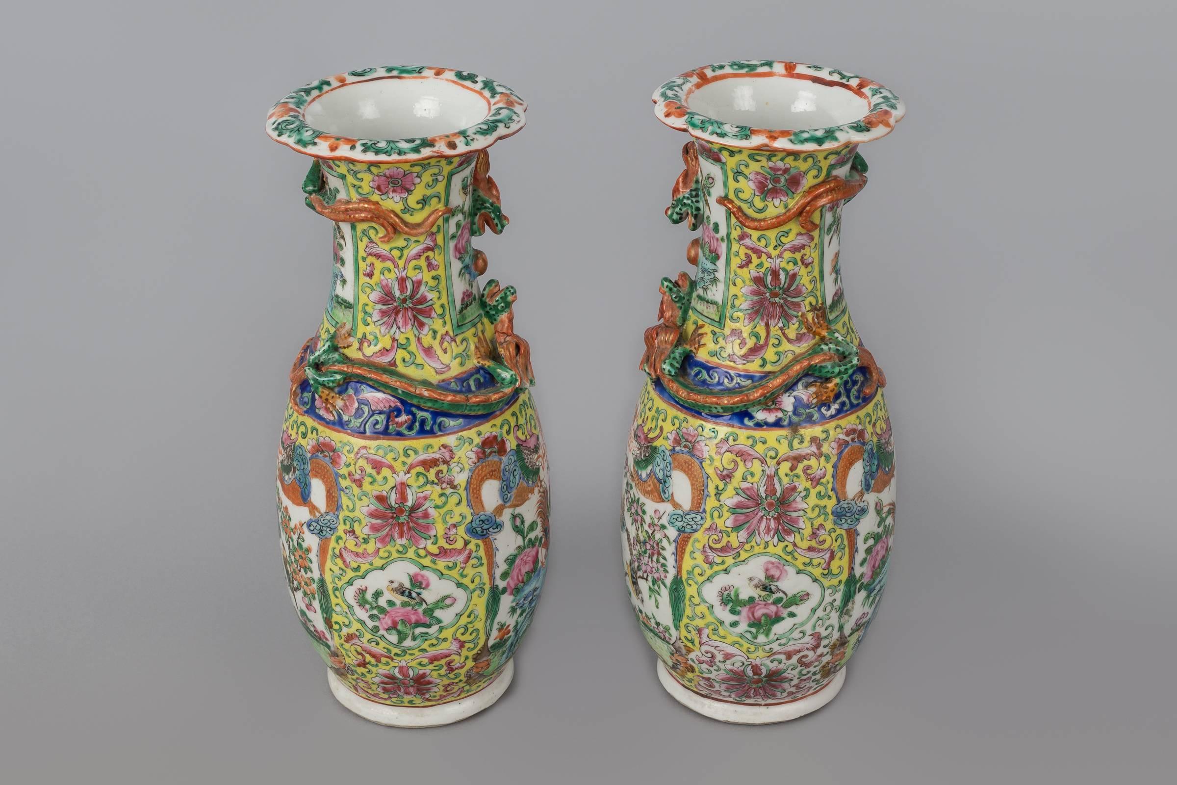 Air Chinese export porcelain polychrome baluster-shaped open vases with scalloped rim, two dragons encircling the neck, two panels enclosing birds, butterflies and flowers framed by two dragons, done in yellow, cobalt blue, pinks, green and orange.