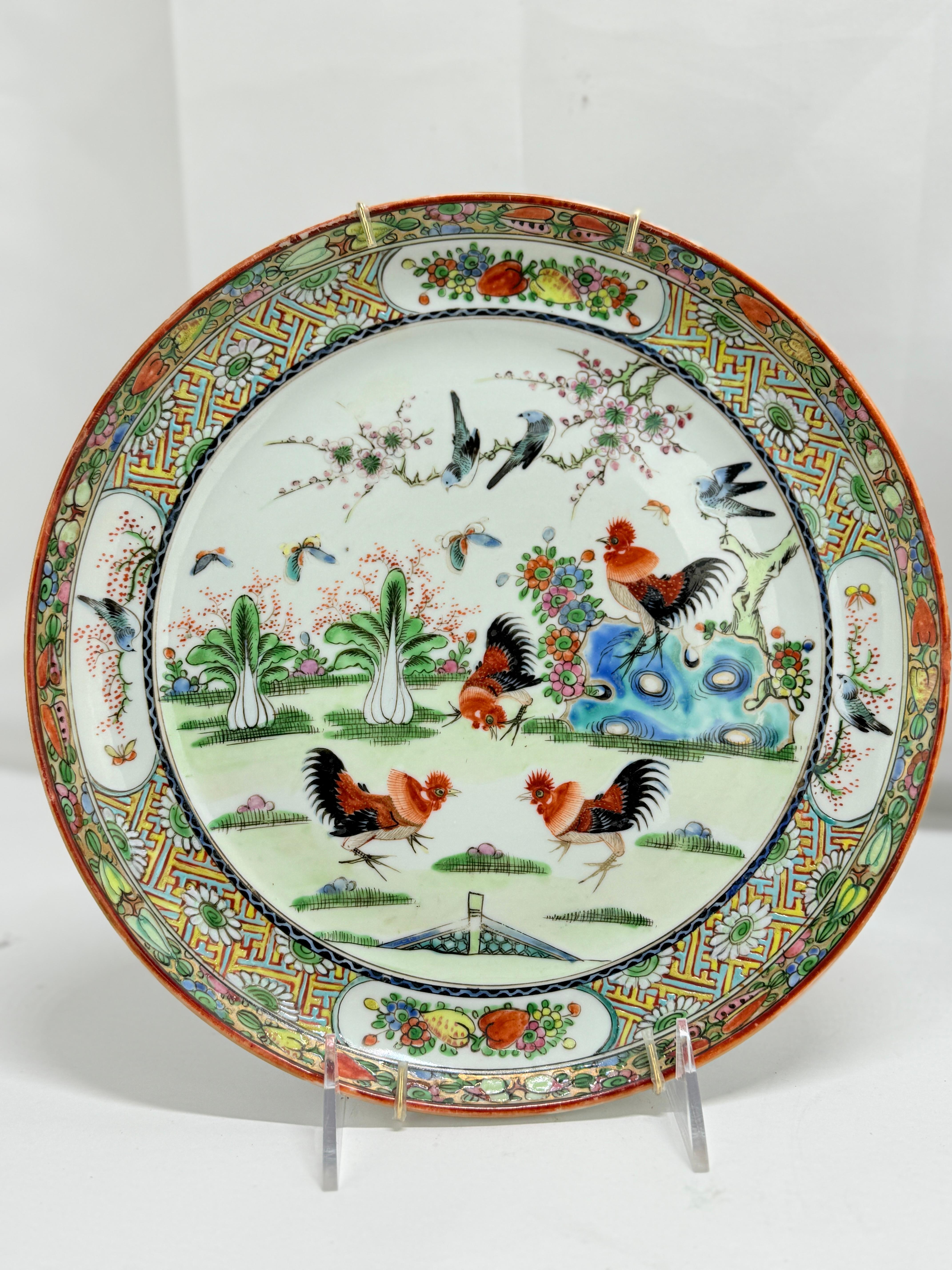 Questa squisita coppia di piatti cinesi in porcellana Famille Rose presenta intricati disegni dipinti a mano, con un gallo e una scena di giardino circondati da un bordo riccamente decorato. Questi piatti esemplificano l'estetica della dinastia