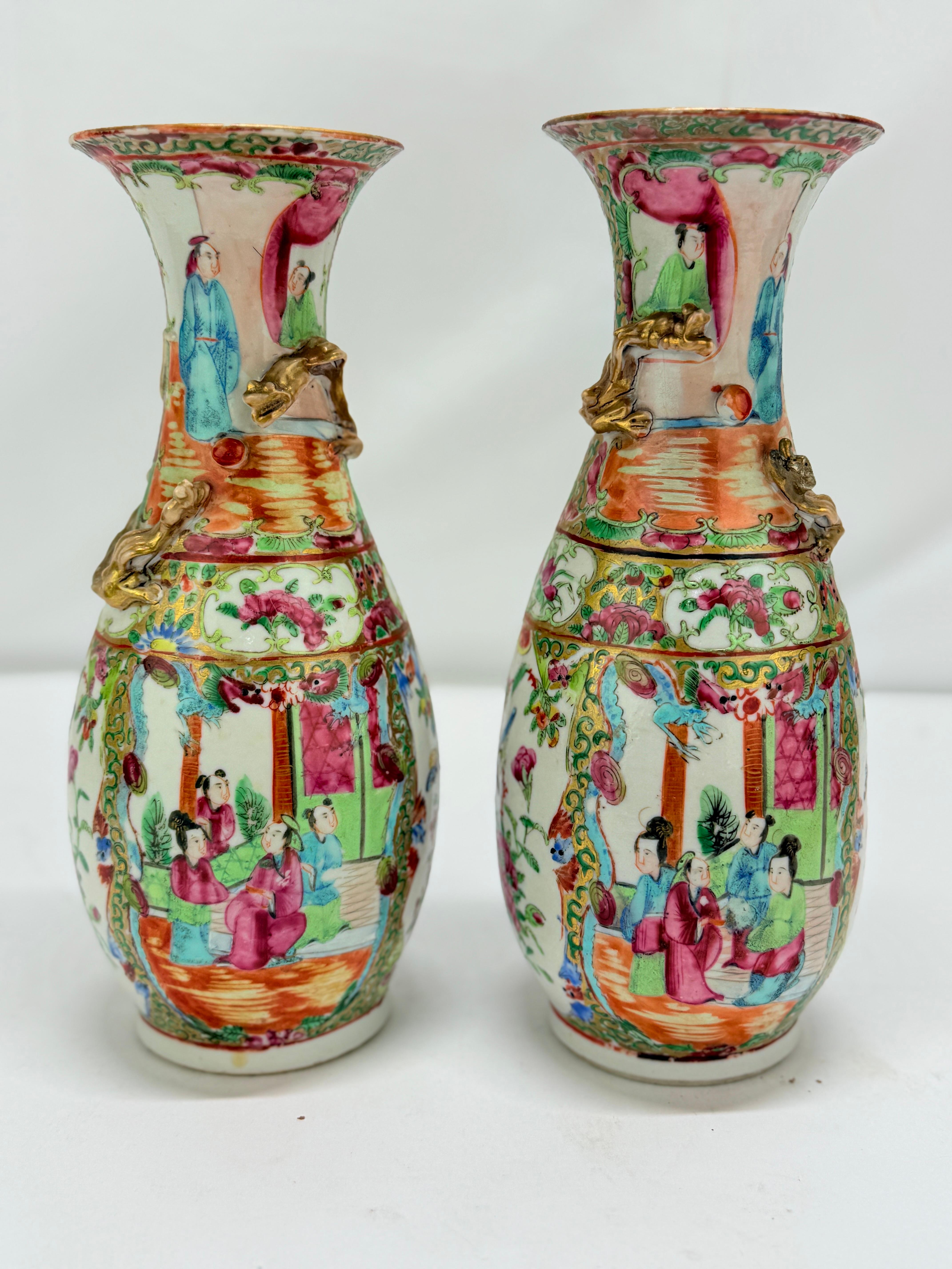 Pareja refinada y visualmente dinámica de jarrones de porcelana china de exportación, de mediados del siglo XIX de la dinastía Qing, ejecutados en la célebre paleta del Medallón Rosa. Cada jarrón tiene forma de balaustre y está decorado a mano con