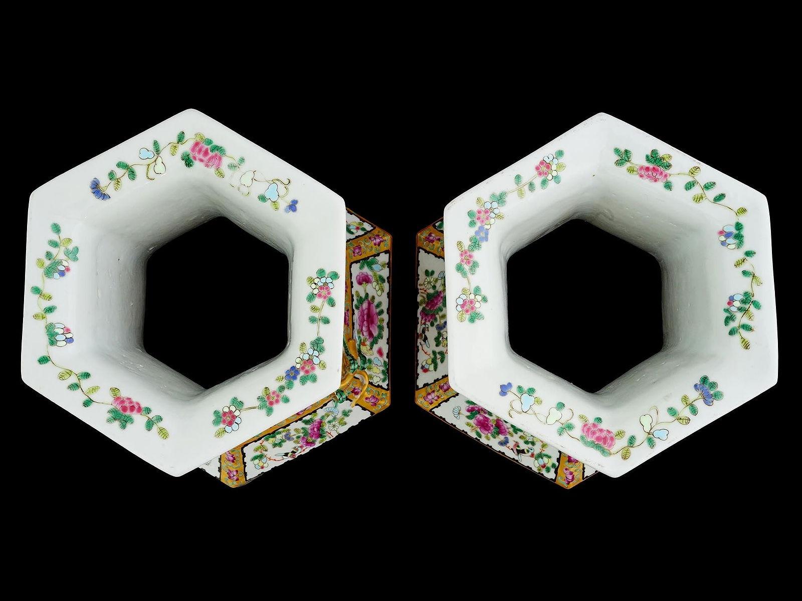 Paire de vases de forme hexagonale en porcelaine de Chine au motif de la famille rose décoré de cartouches représentant des fleurs et des scènes de cour, et d'anses en forme de baies de vigne.