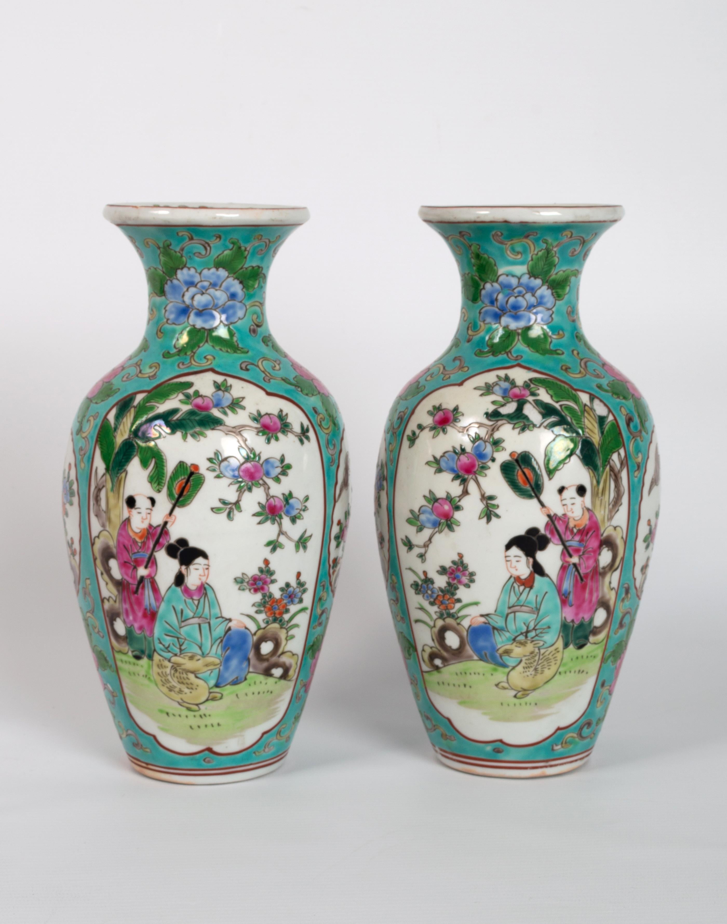 Paar chinesische Vasen in Famille rose mit türkisfarbenem Grund C.1940.

Emailliert in Famille-Rose-Palette mit großen Blüten, die um einen Rand aus gewundenen Ranken getragen werden. Der zentrale Vasenkörper stellt eine gefächerte sitzende Frau