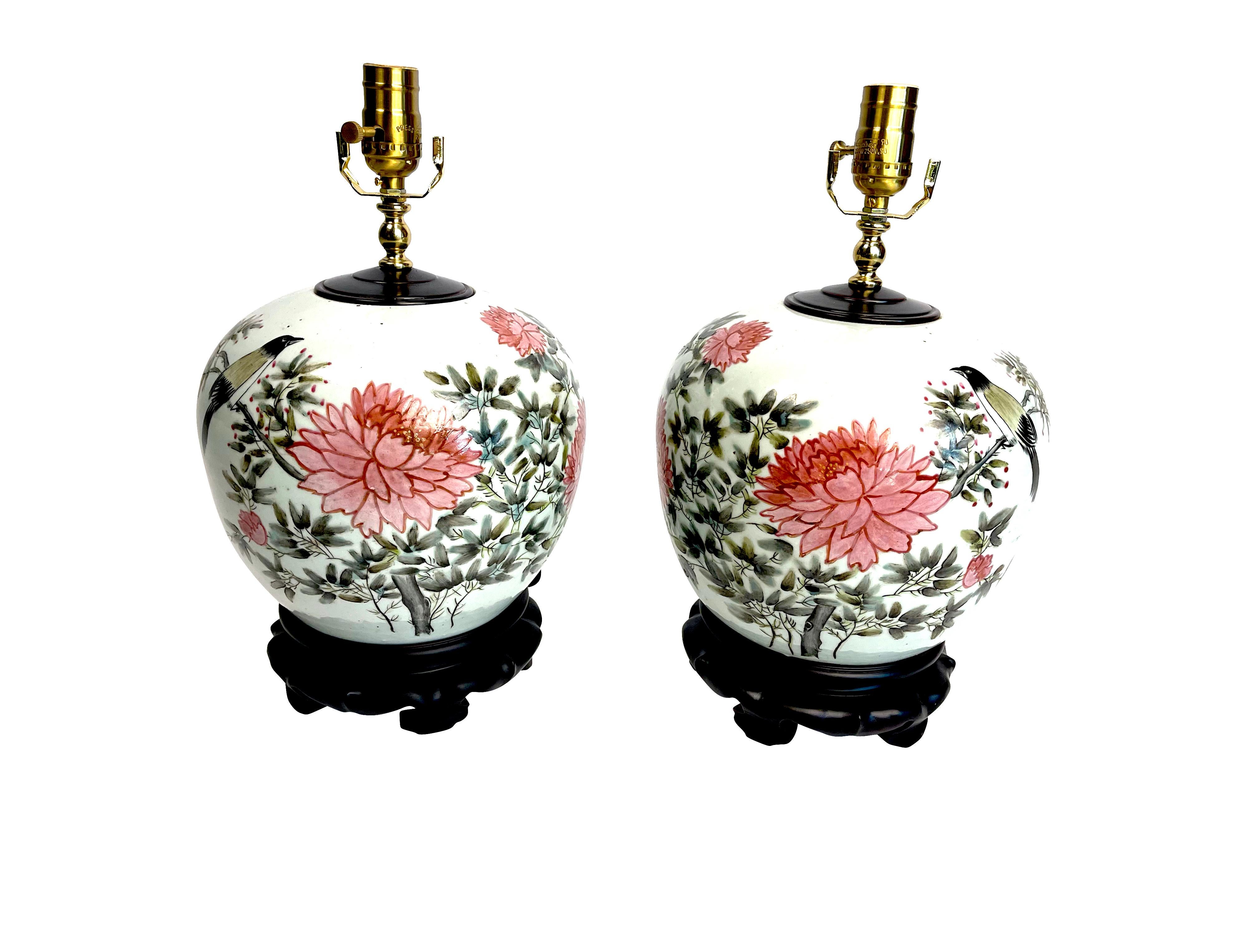 Pair of Chinese ginger jar chrysanthemum Porcelain lamps beautiful hand painted pink and green flowers on white porcelain ginger jars with Chinese characters made into lamps.
Measuring 15.75 height x 8.5 x 9.25 diameter.