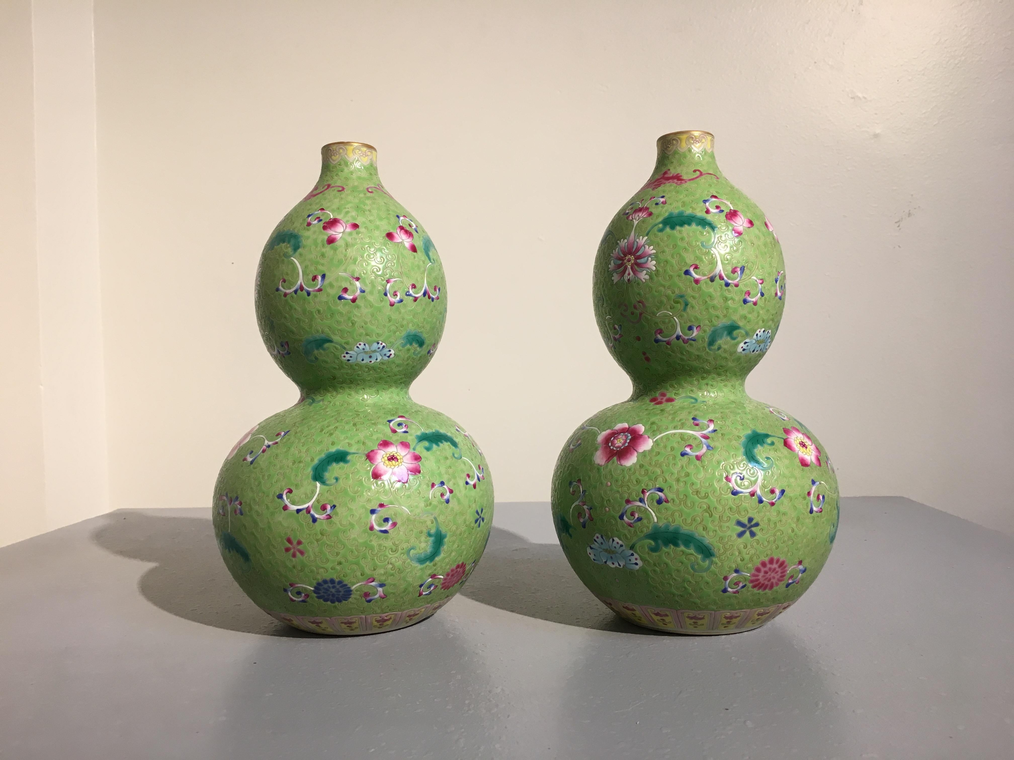 A striking pair of Chinese double gourd porcelain vases finely decorated in Famille rose enamels on a lime green sgraffito ground, Republic period (1912-1949), mid-20th century, China.

The decoration reminiscent of Qing imperial wares, with lotus