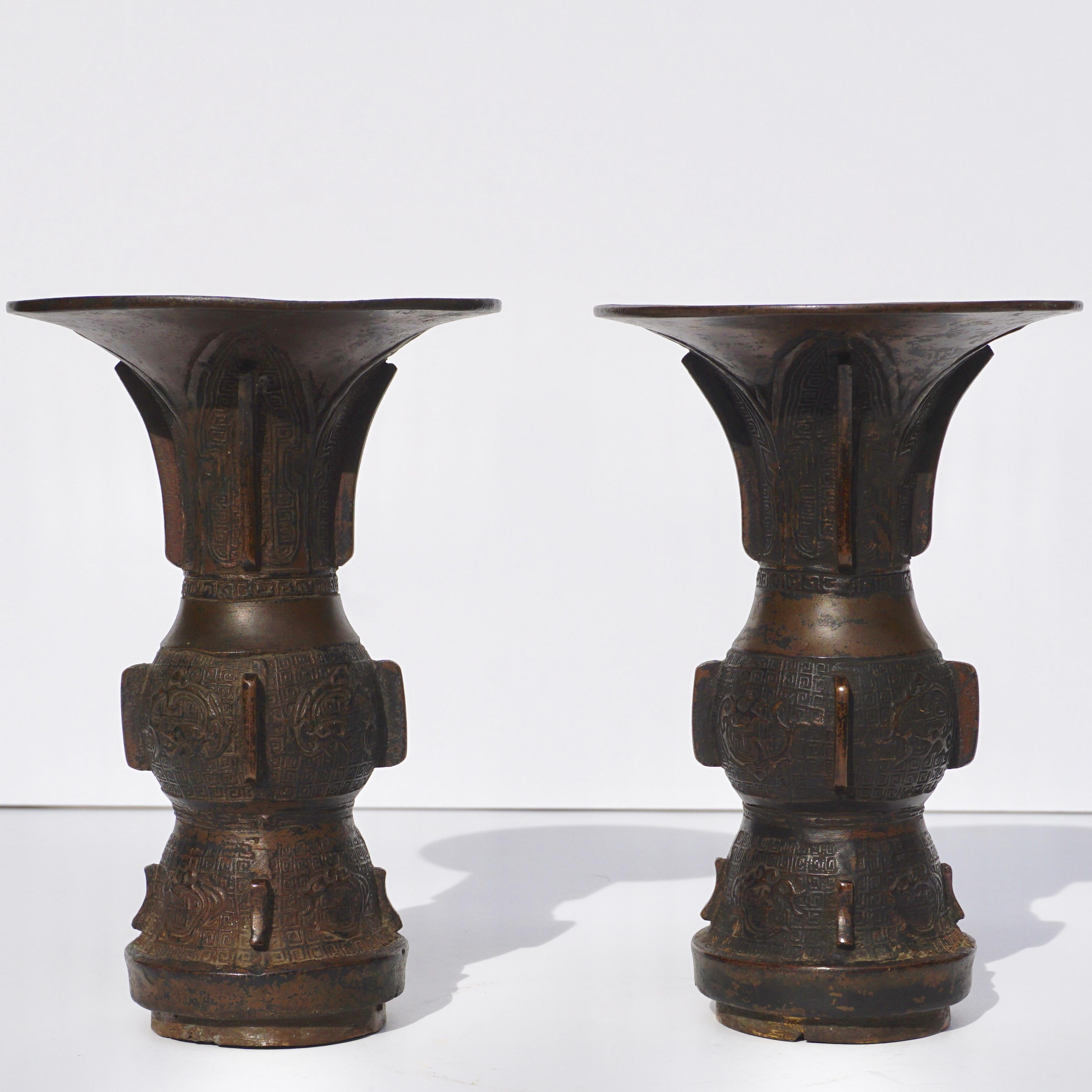 A rare pair of bronze cast archaistic Gu vases with wood bases, 17th century. Late Ming-early Qing dynasty Chinese.

Measures: Height 6.5 inches
Diameter 4 inches

Condition: Wear commensurate of age and use.