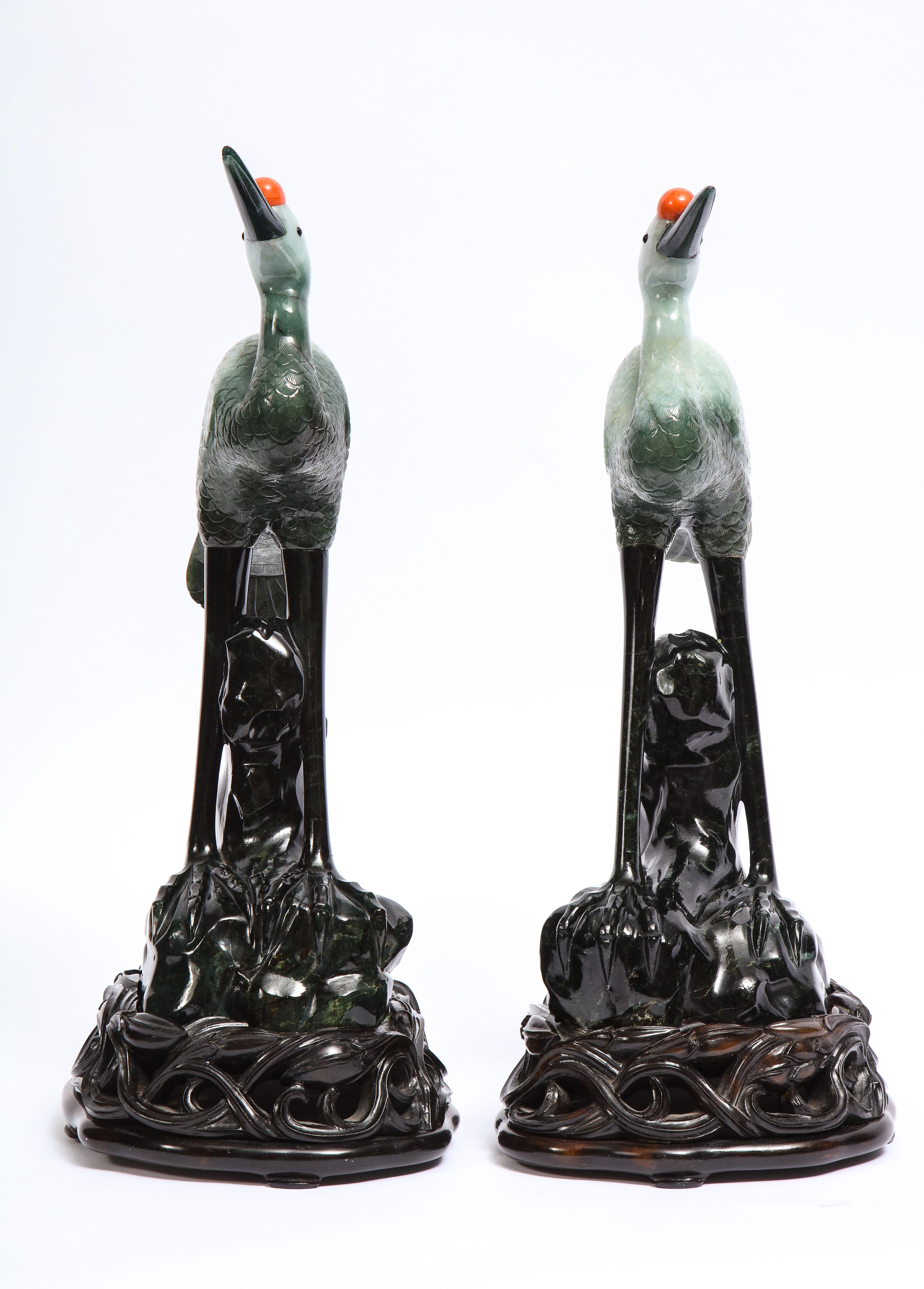 Chinois Paire de sculptures chinoises en jadéite vert clair mouchetée, grues sur socle en bois sculpté en vente