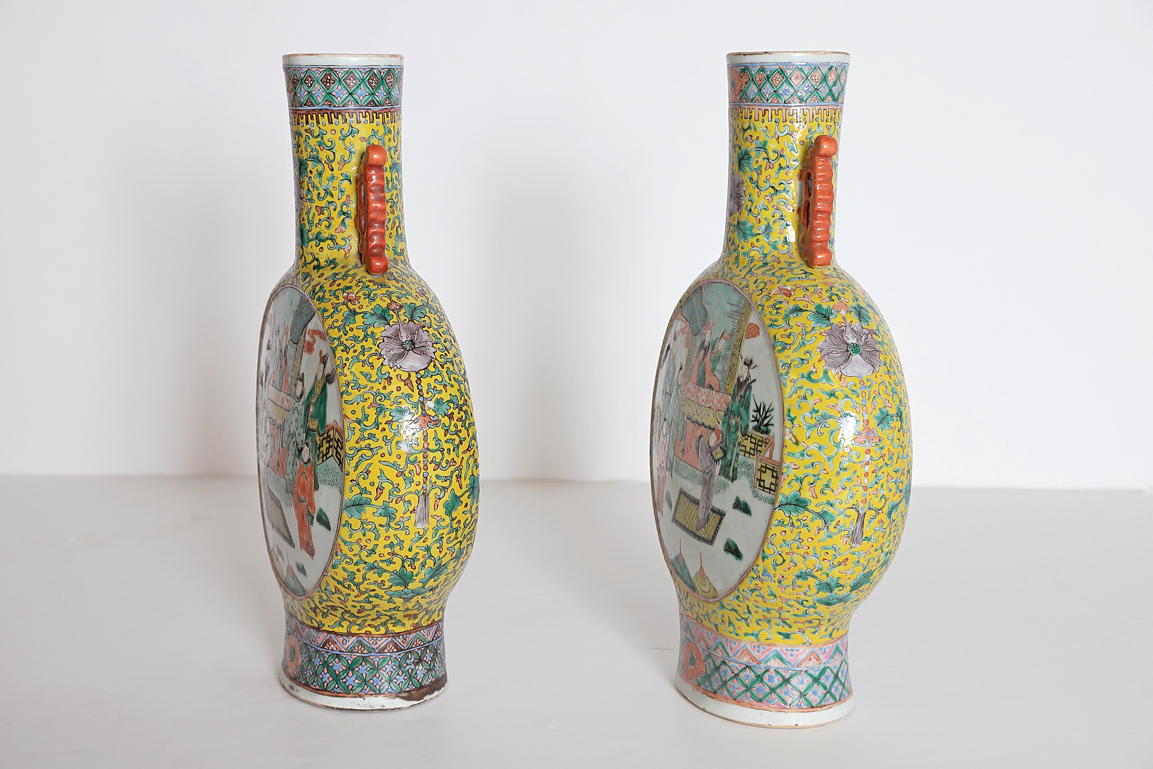 Two (2) Chinese porcelain moon flask vases, a true pair, yellow ground with green and pink flowering vine design with purple flowers, white panels front and back with interior and exterior / landscape scenes, including people and horses (each the